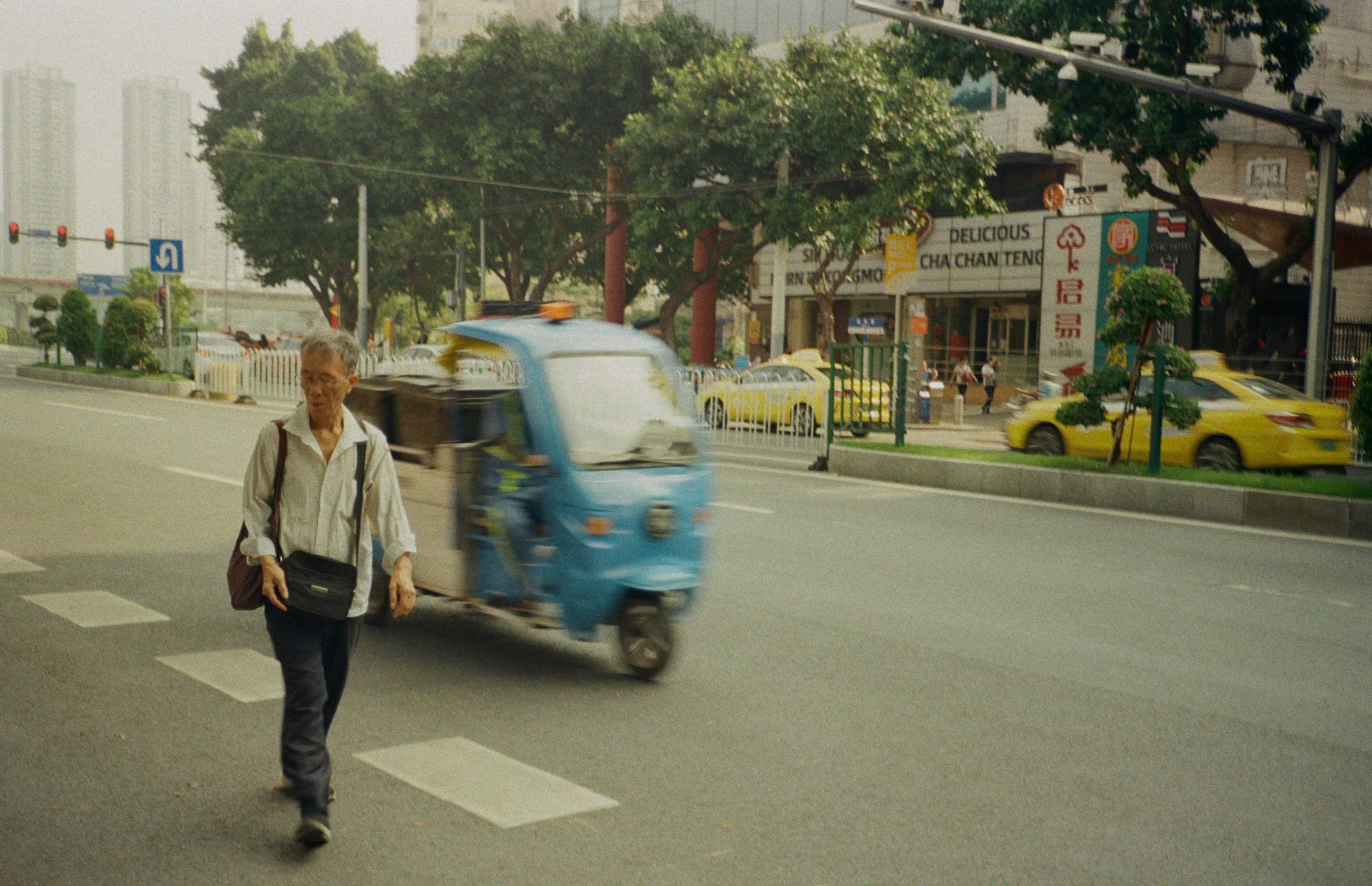 Un hombre caminando por una calle junto a un camión azul