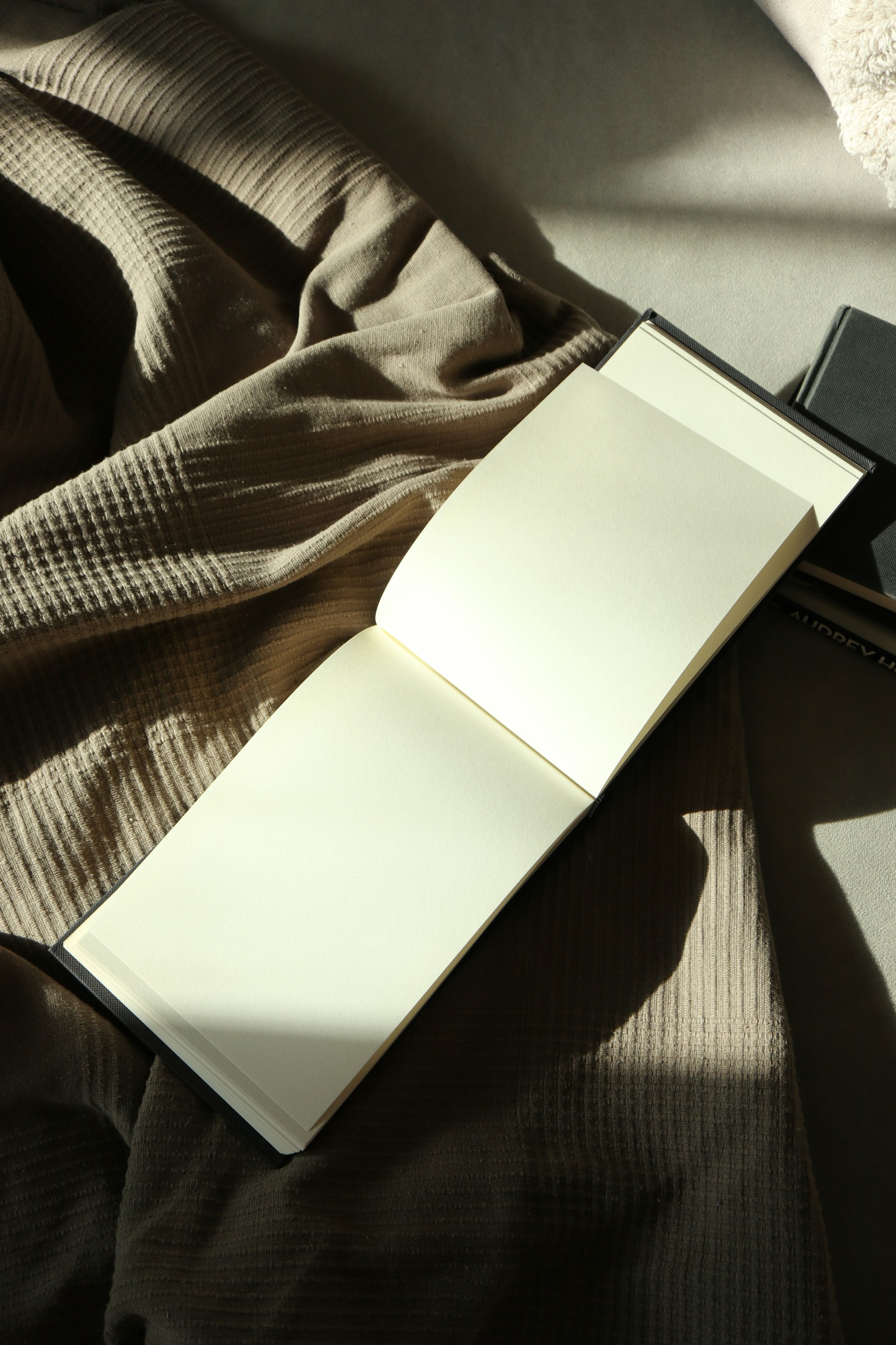An open notebook sitting on top of a bed