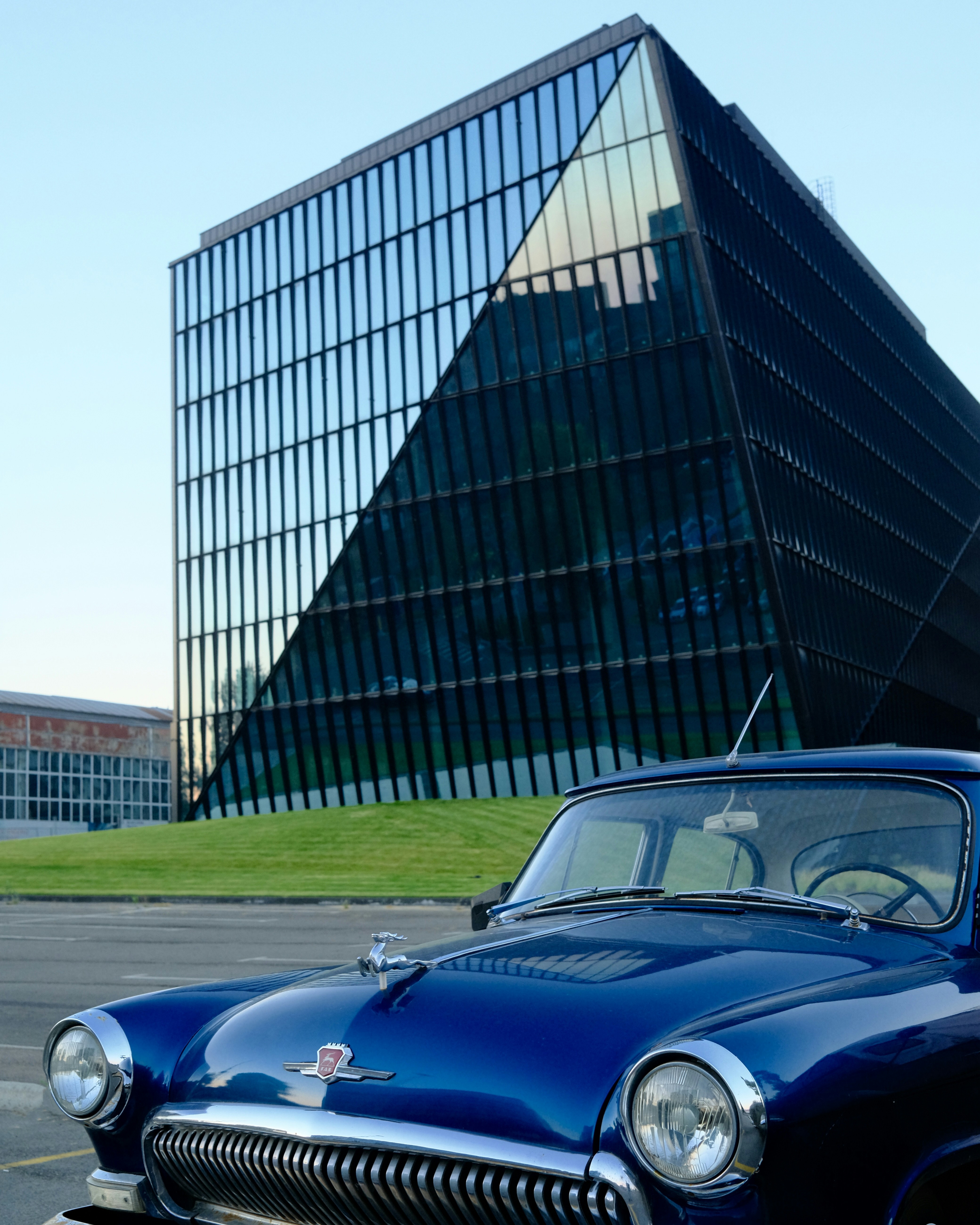 A blue car parked in front of a building