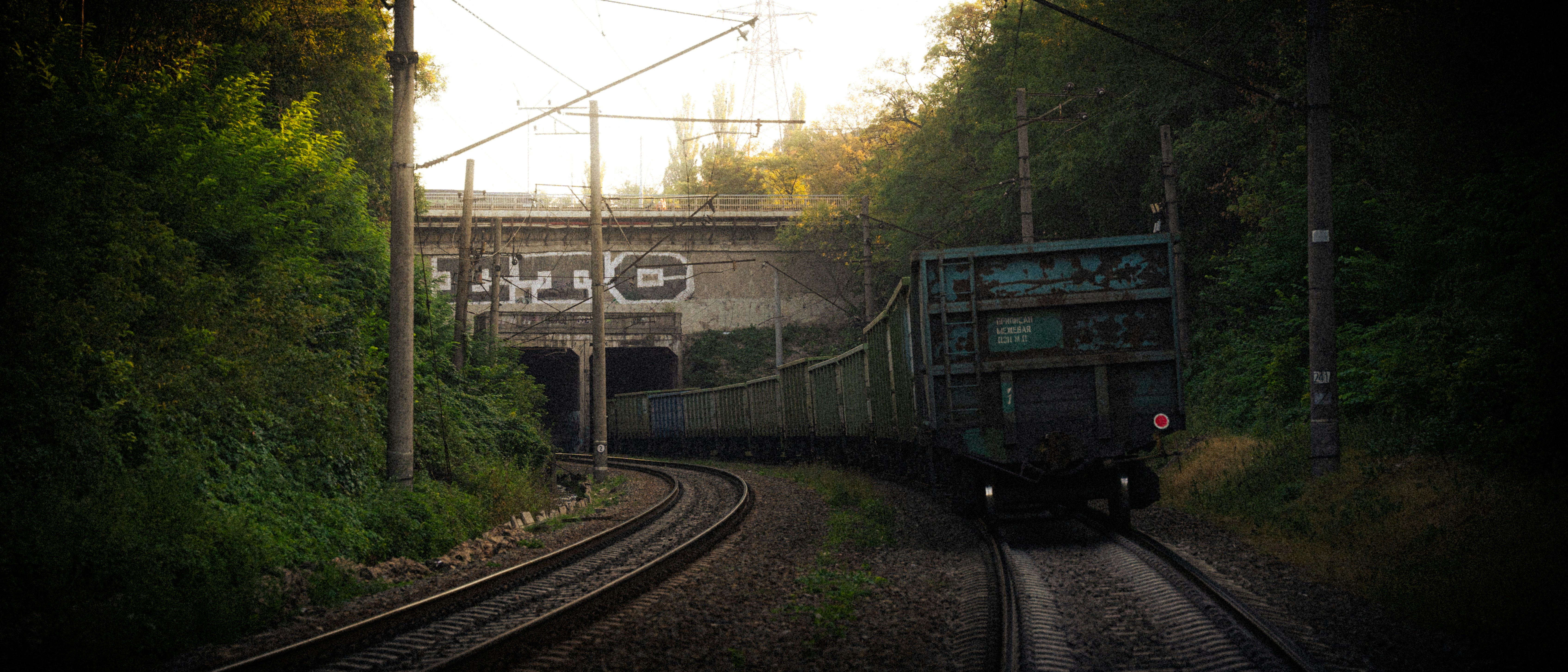 A train traveling down train tracks next to a bridge