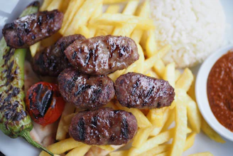 A white plate topped with meat and french fries