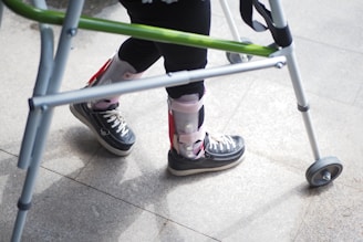 A person standing next to a green walker