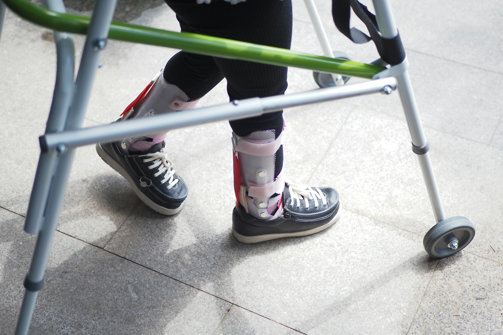 A person standing next to a green walker