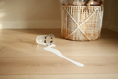 A basket with a toothbrush on a wooden floor