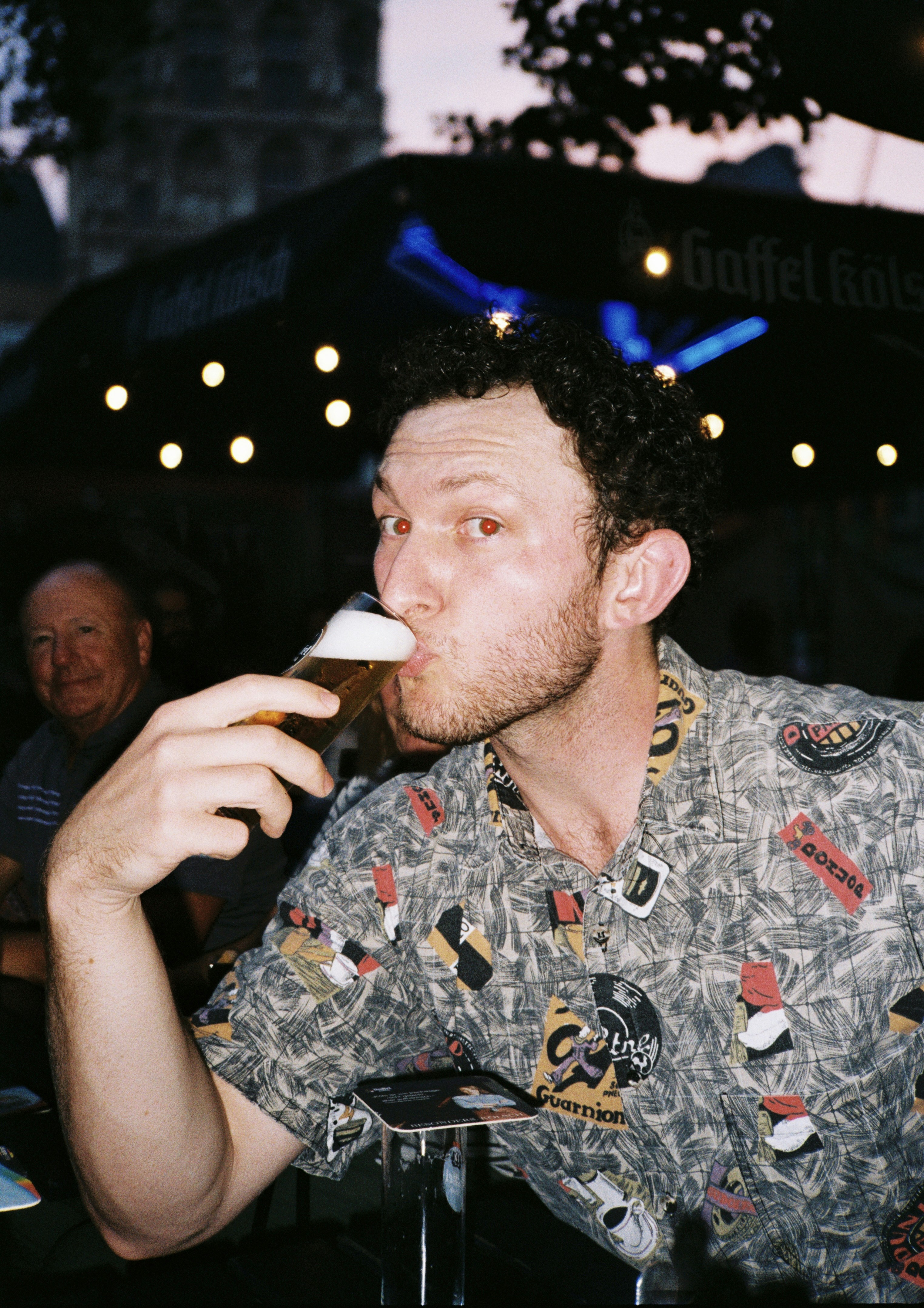 A man sitting at a table drinking a beer