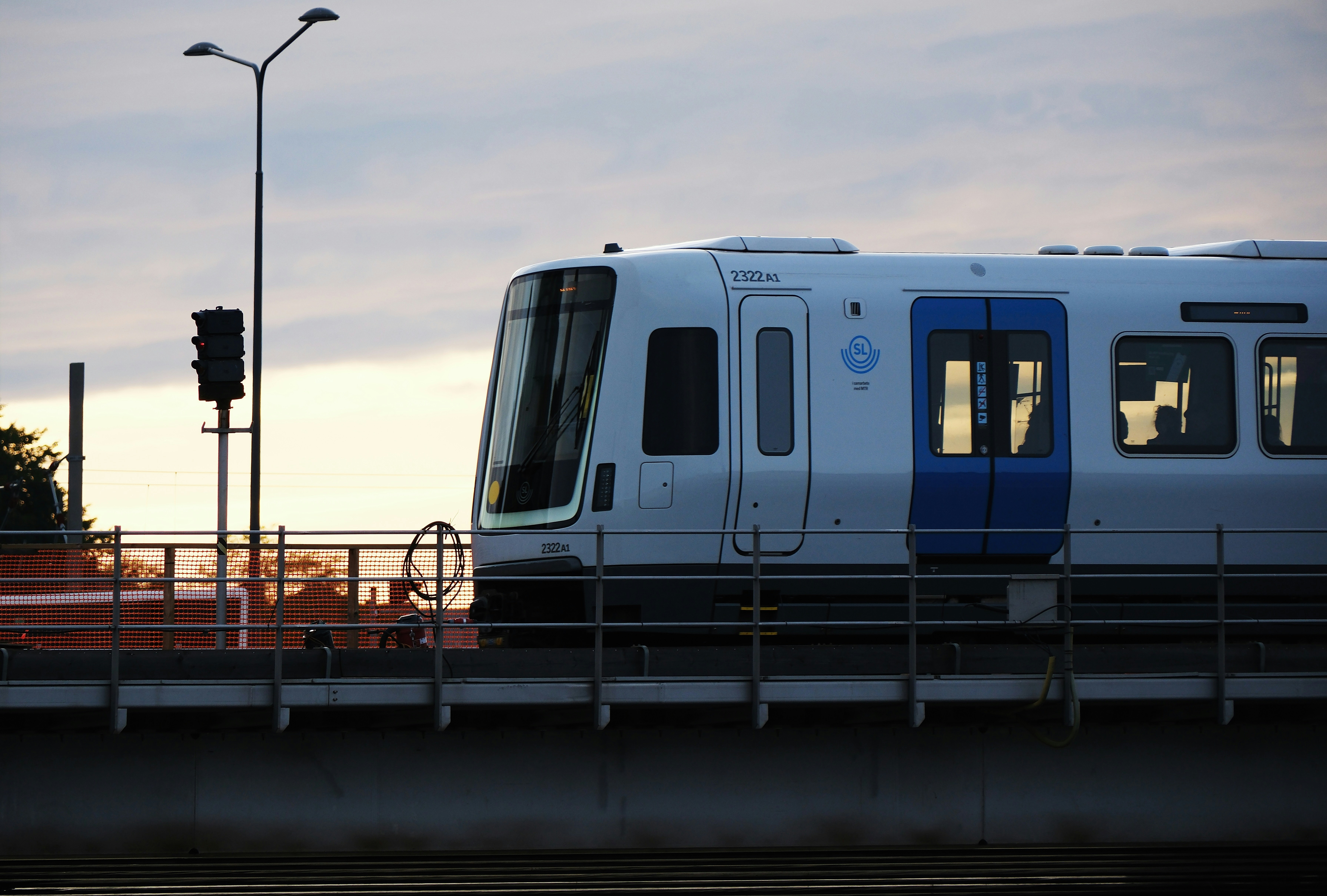 A white and blue train traveling over a bridge