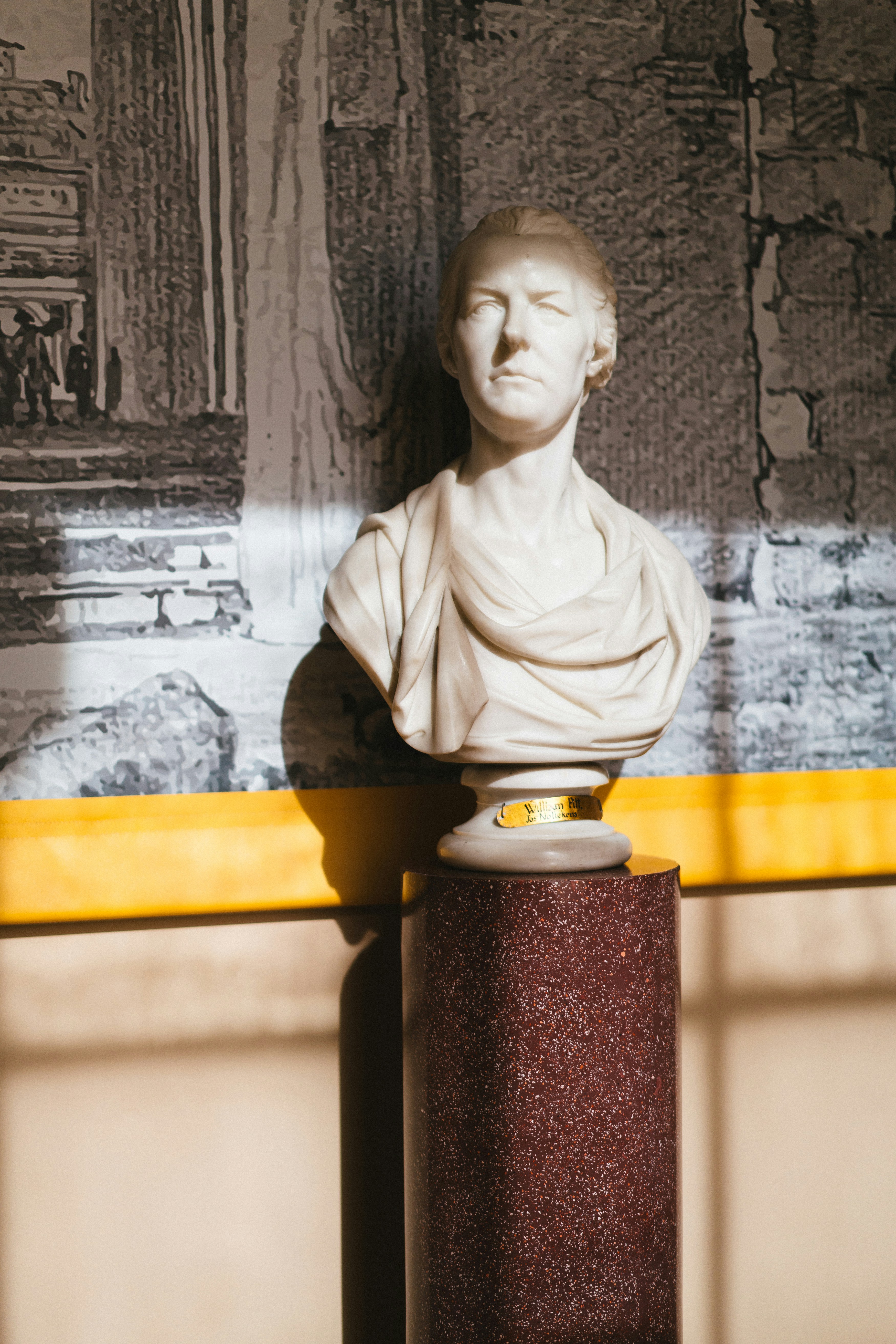 A bust of a man in front of a painting