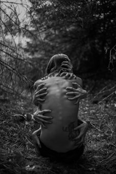 A person sitting on the ground in the woods