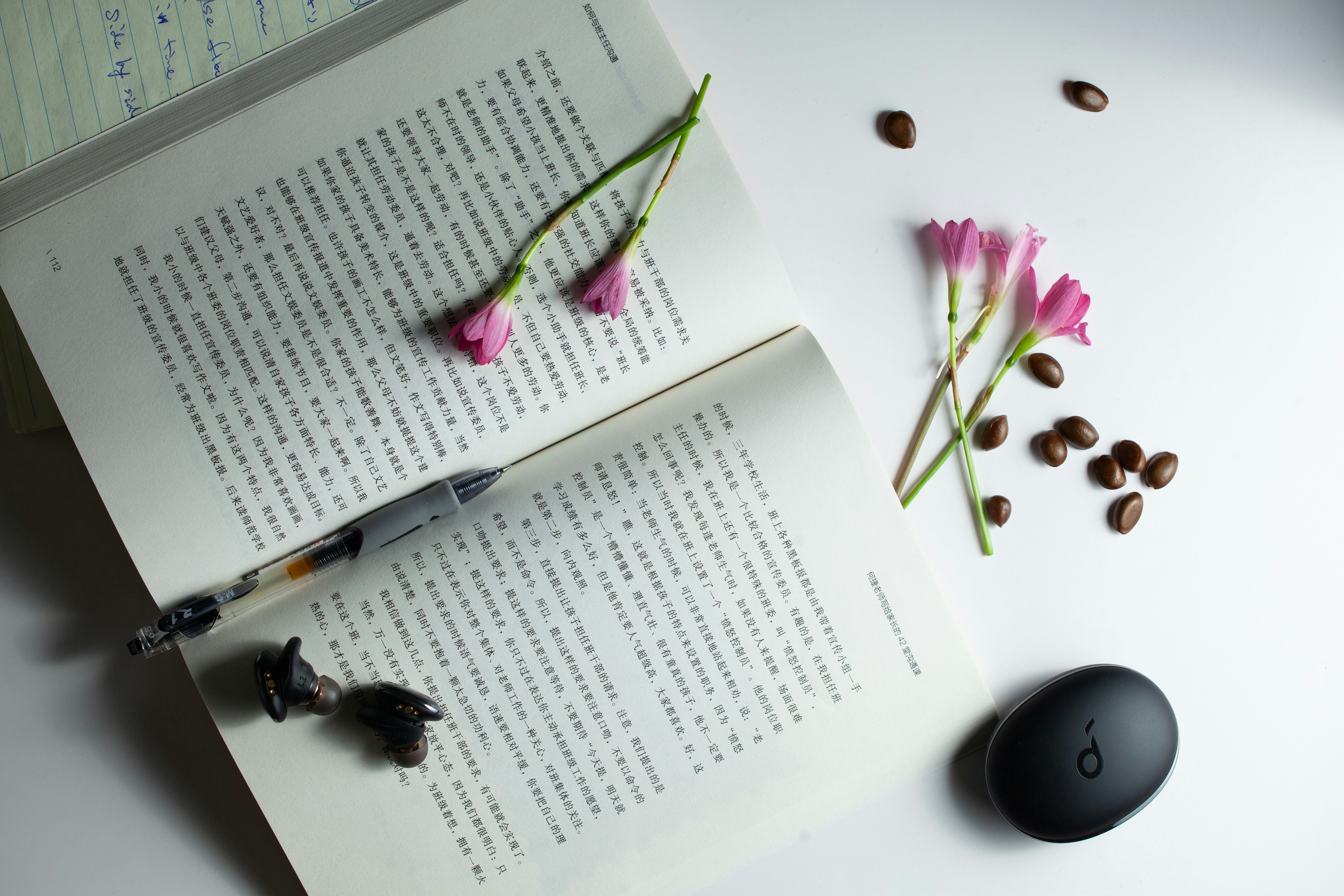 A book with a pen and some flowers on top of it