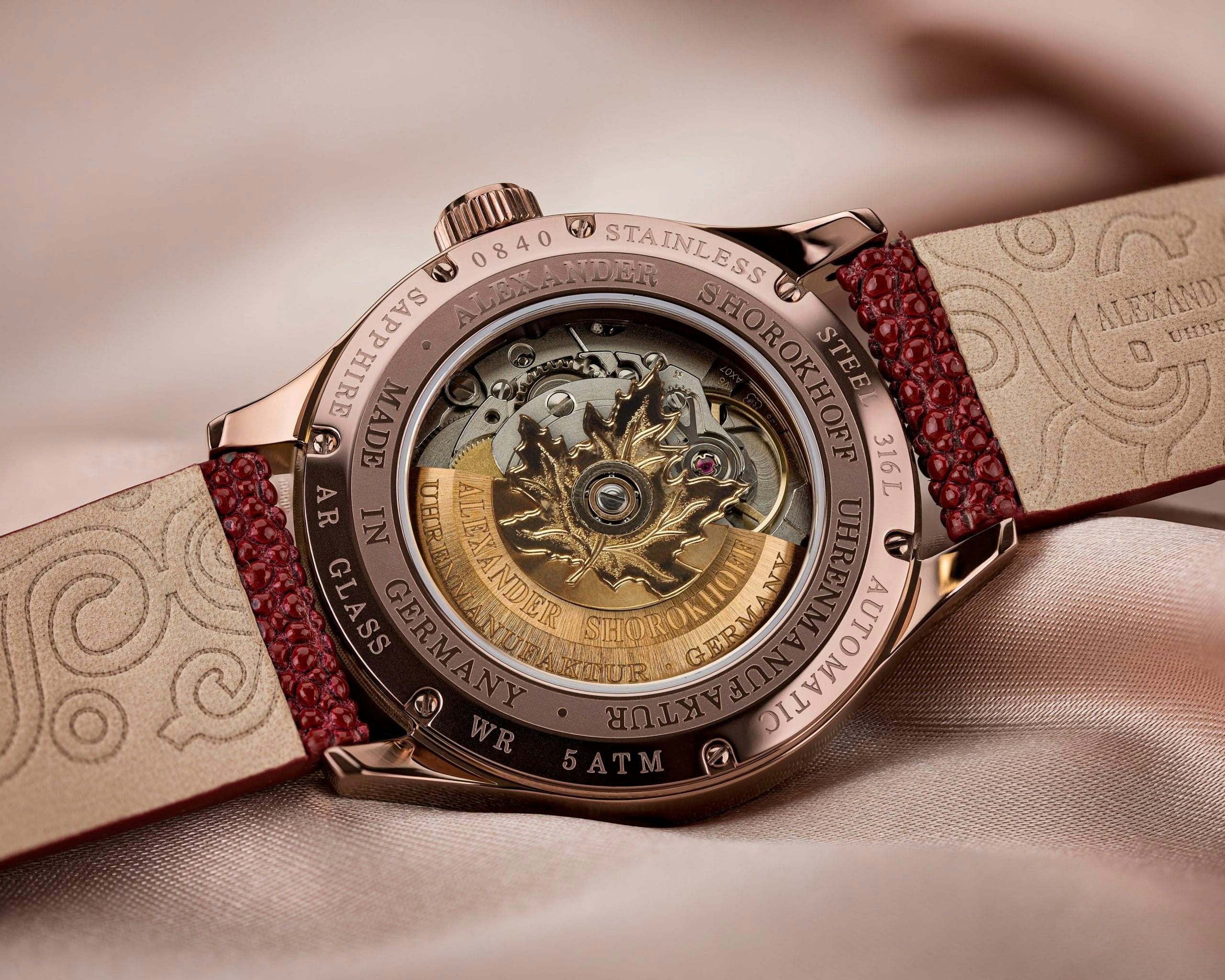 A close up of a watch on a bed