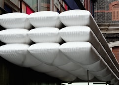 A bunch of white frisbees hanging from the side of a building