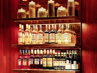 A shelf filled with lots of bottles of liquor