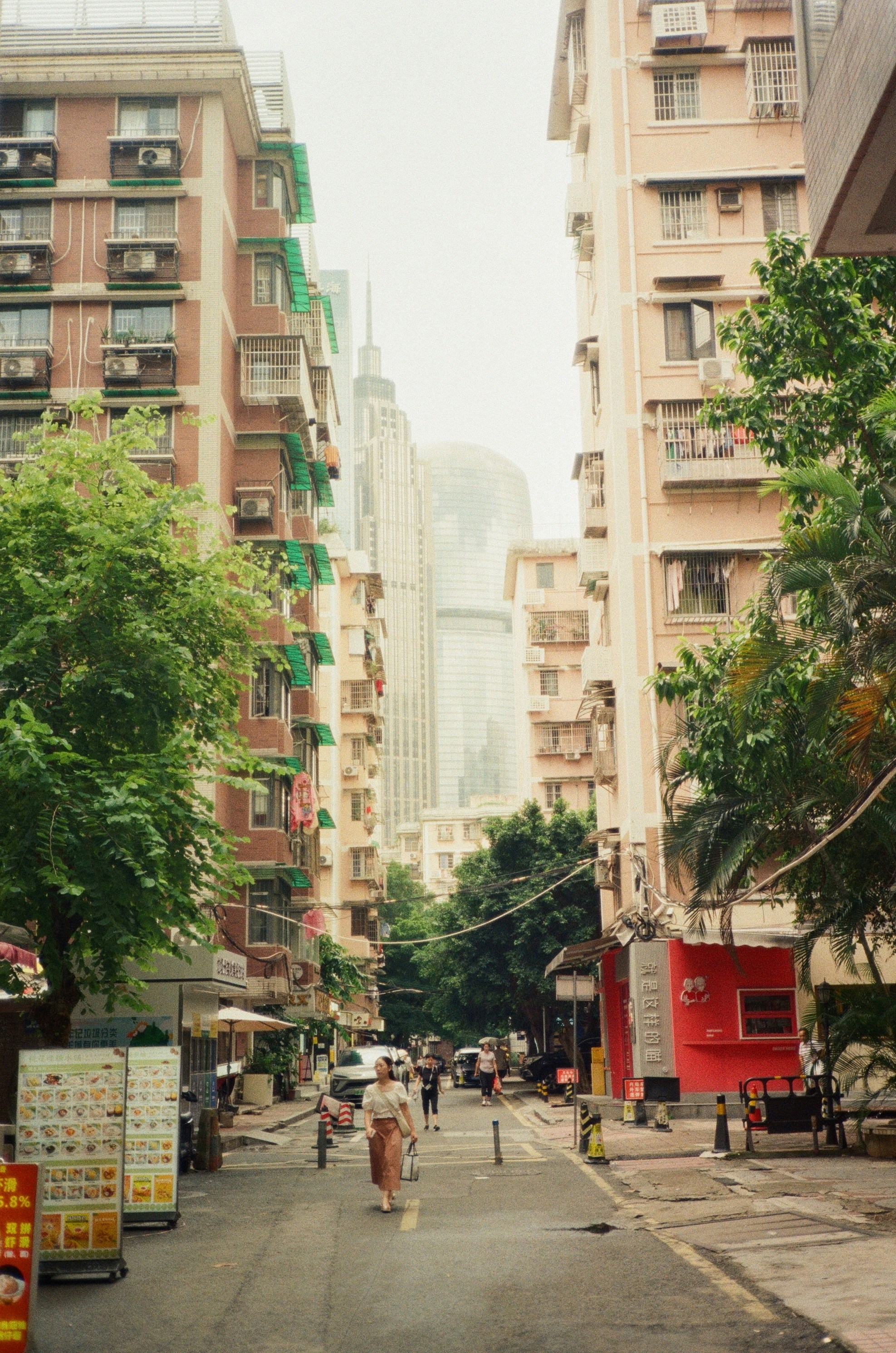 A city street with tall buildings and people riding bicycles