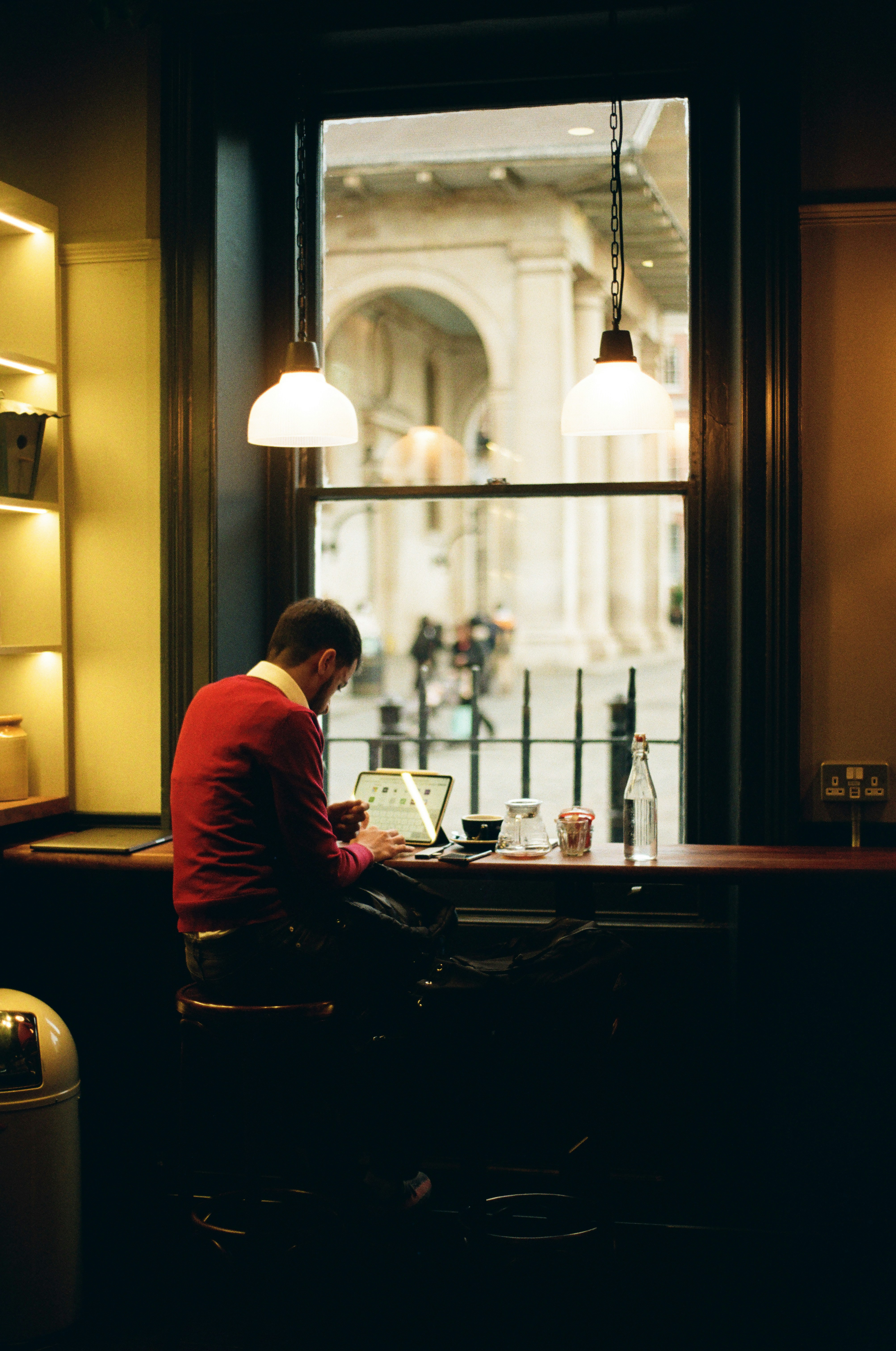 Un homme assis à une table devant une fenêtre