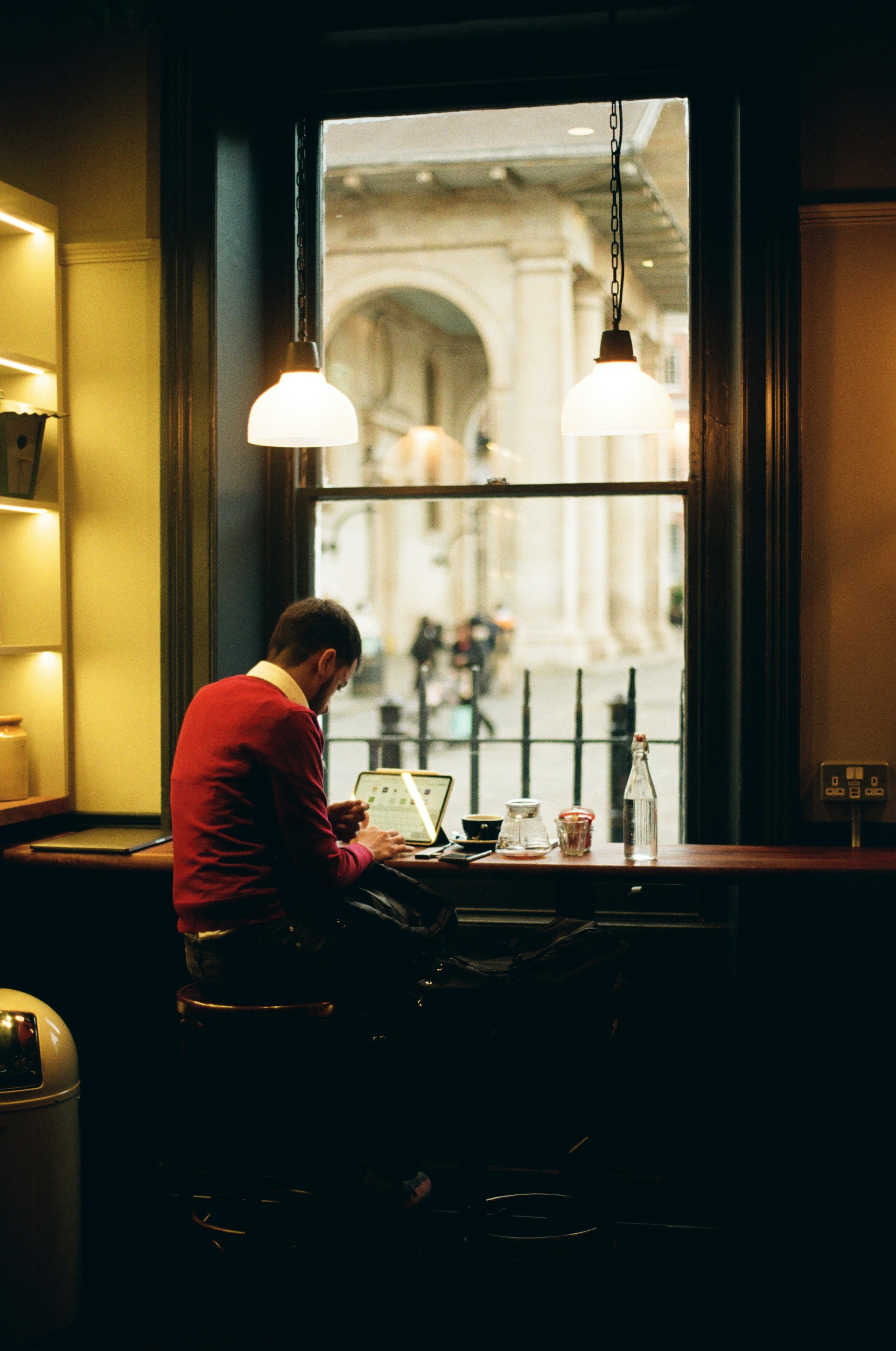 A man sitting at a table in front of a window