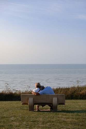 A man sitting on a bench looking at the ocean