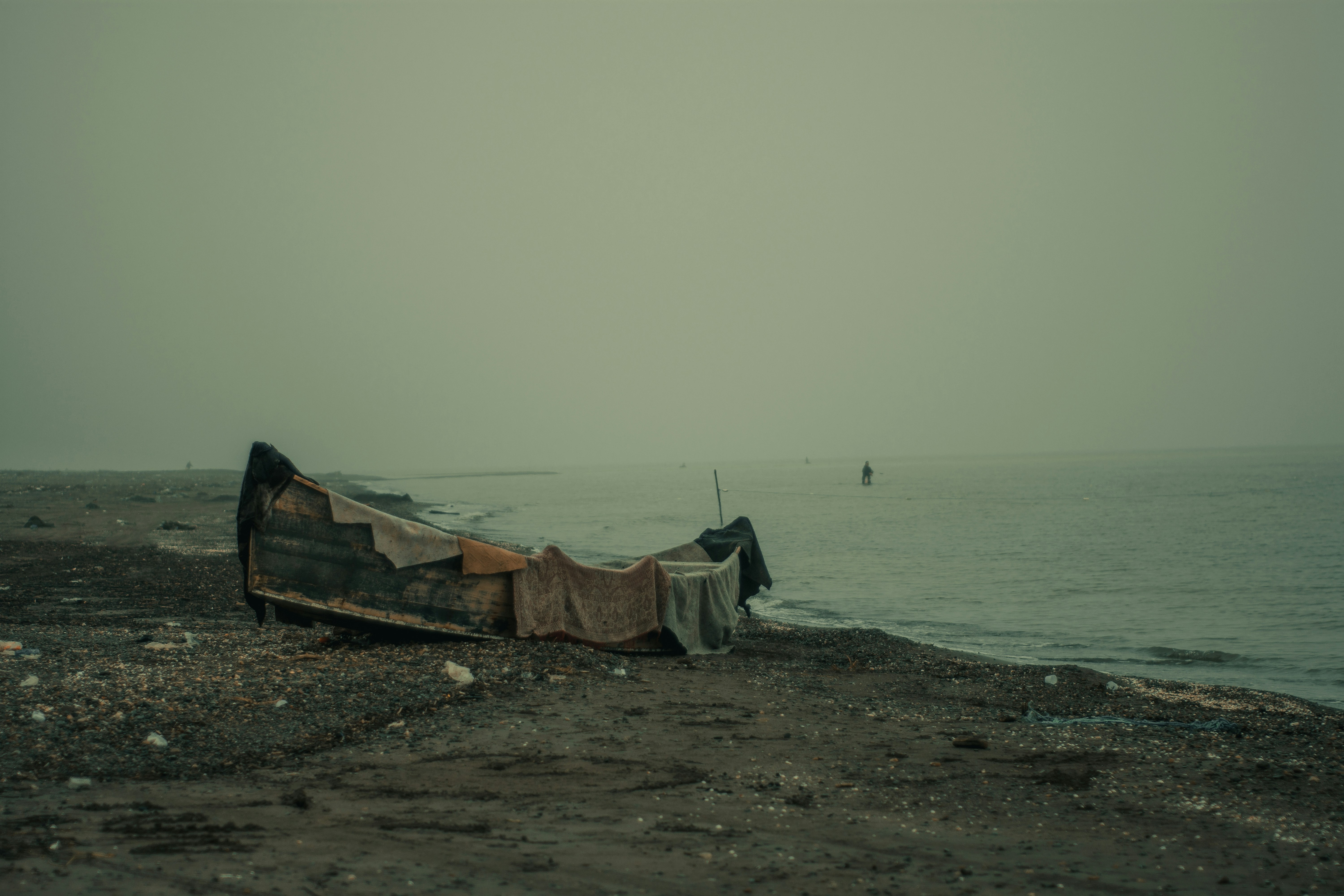 A boat sitting on top of a beach next to the ocean