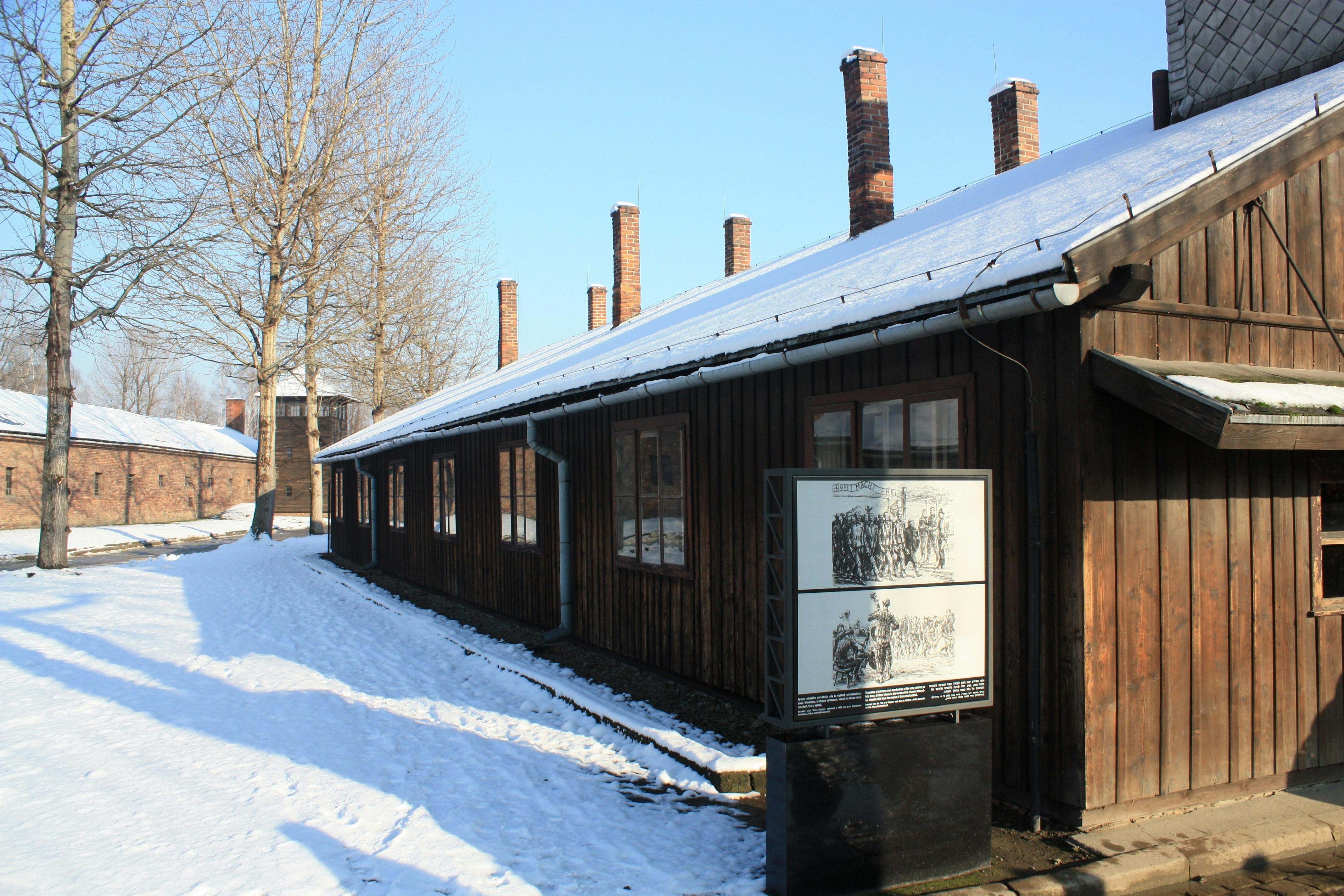 A building with snow on the ground and trees in the background