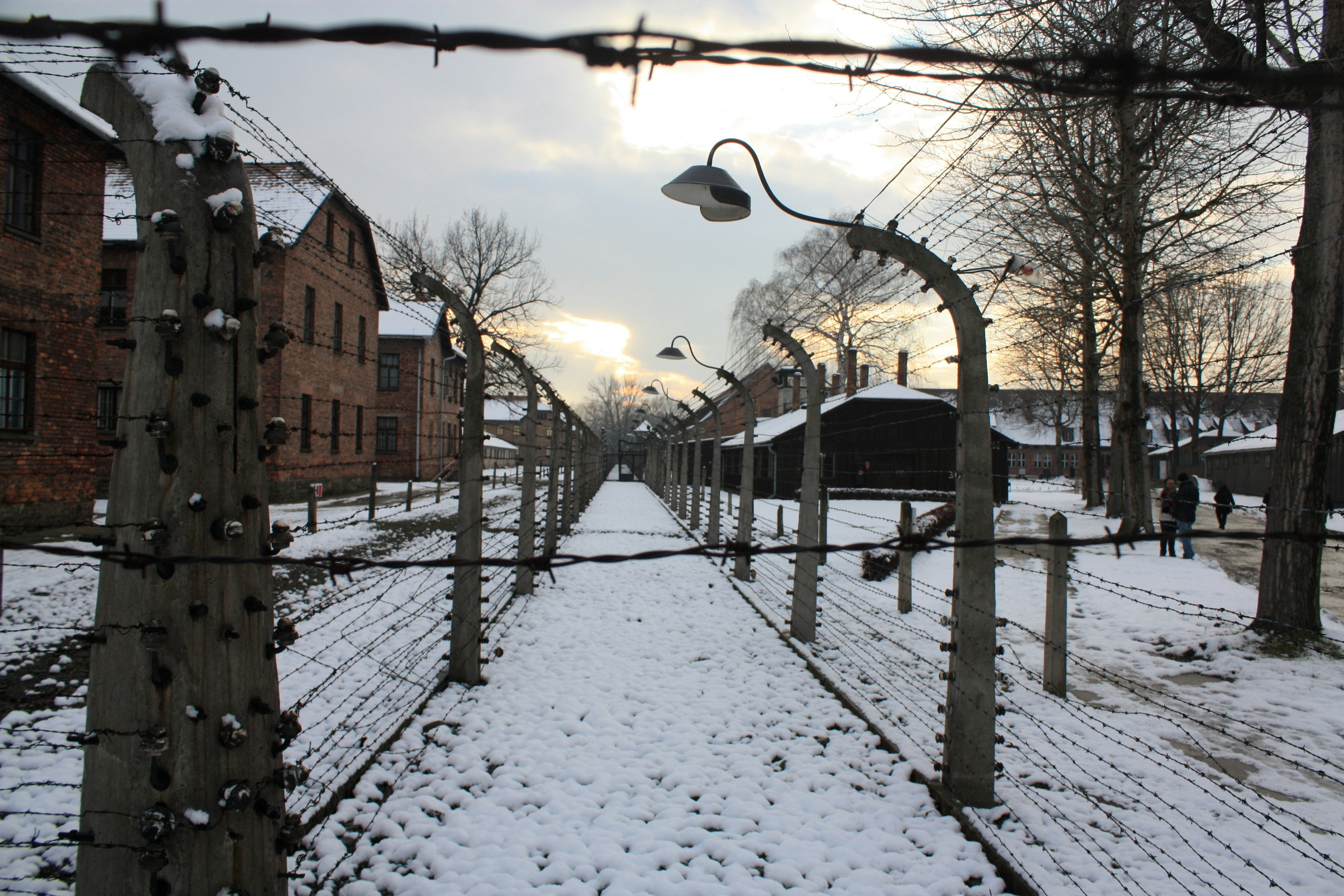 A snow covered street next to a fence