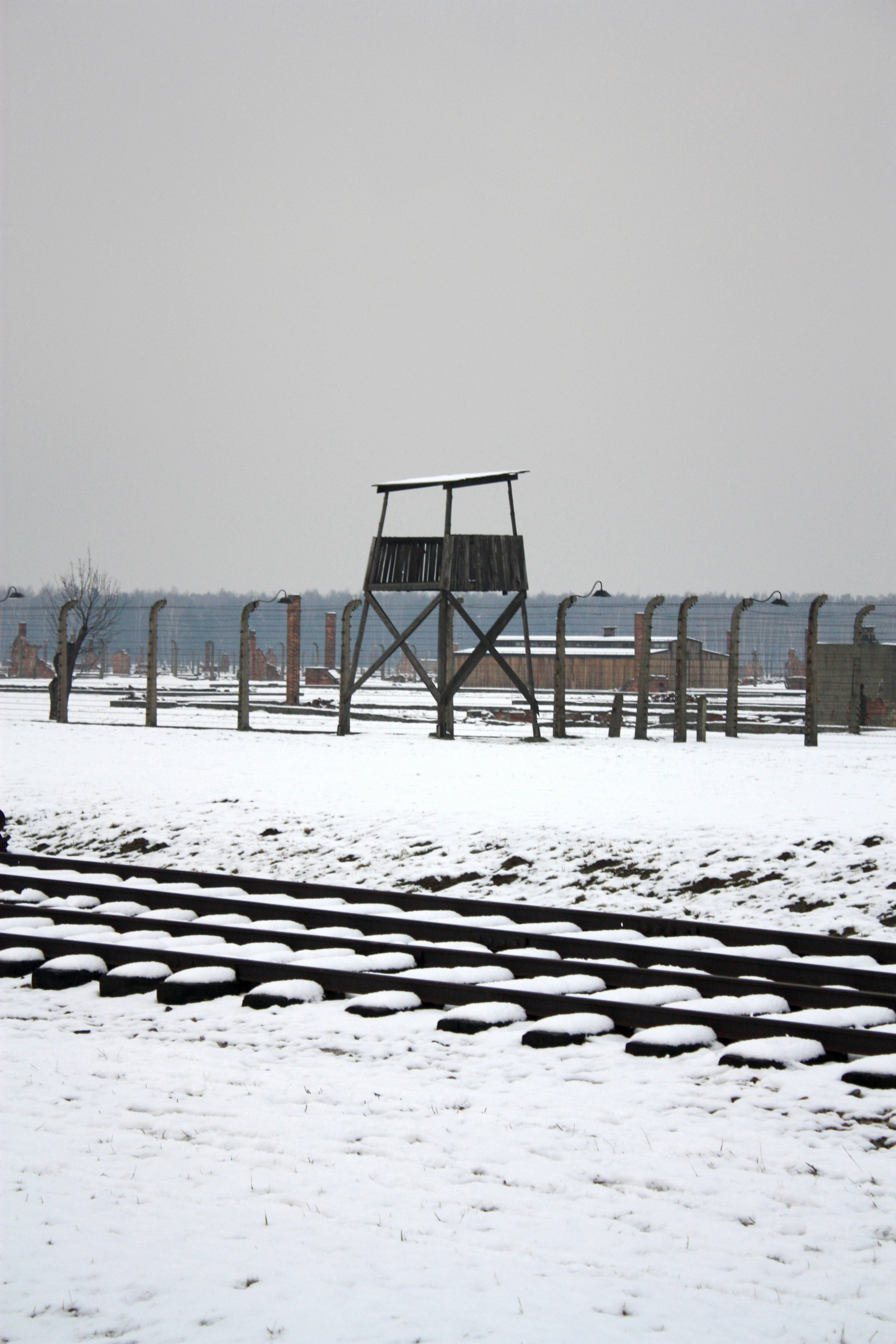 A train track in the snow with a tower in the background