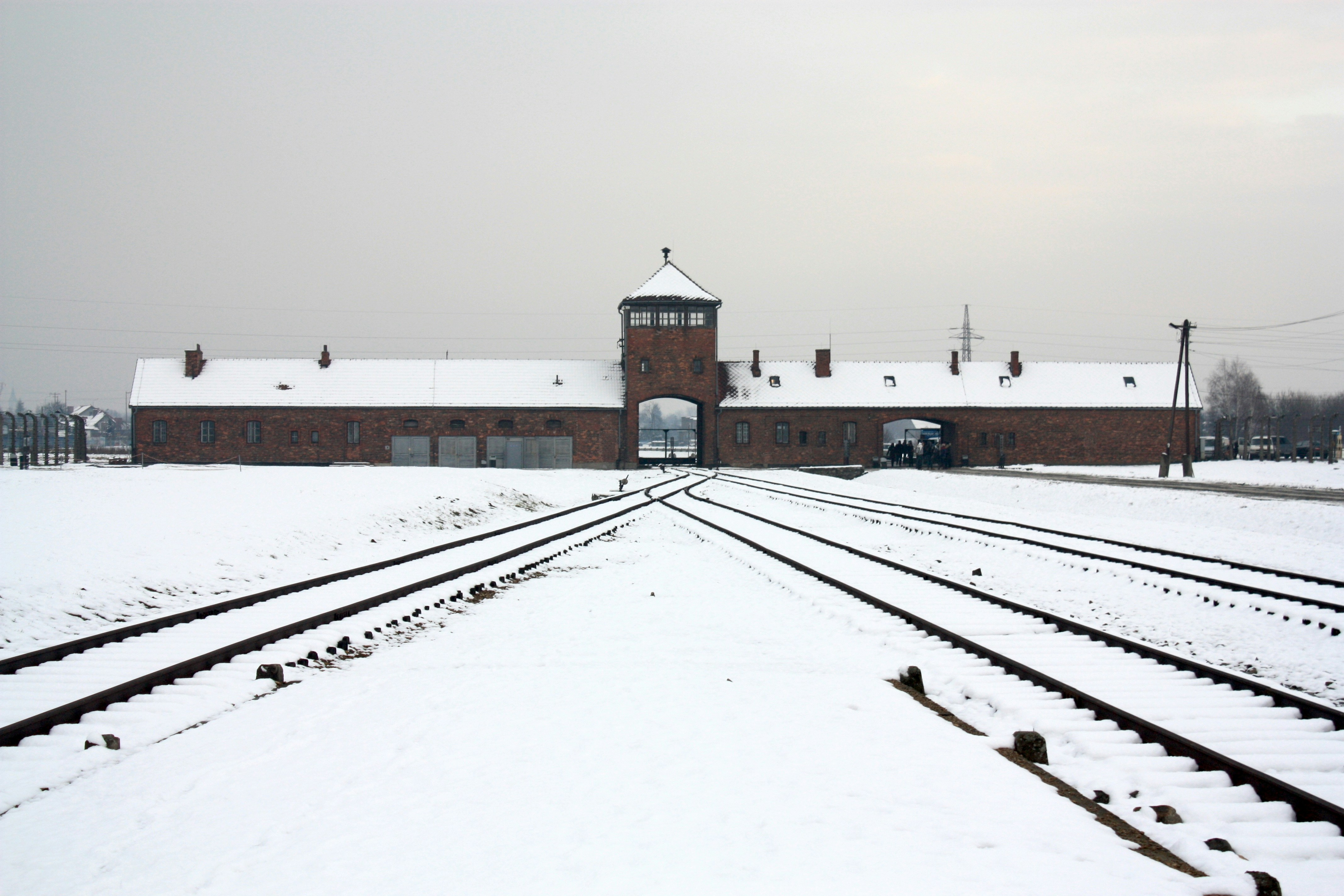 A train track in front of a building covered in snow