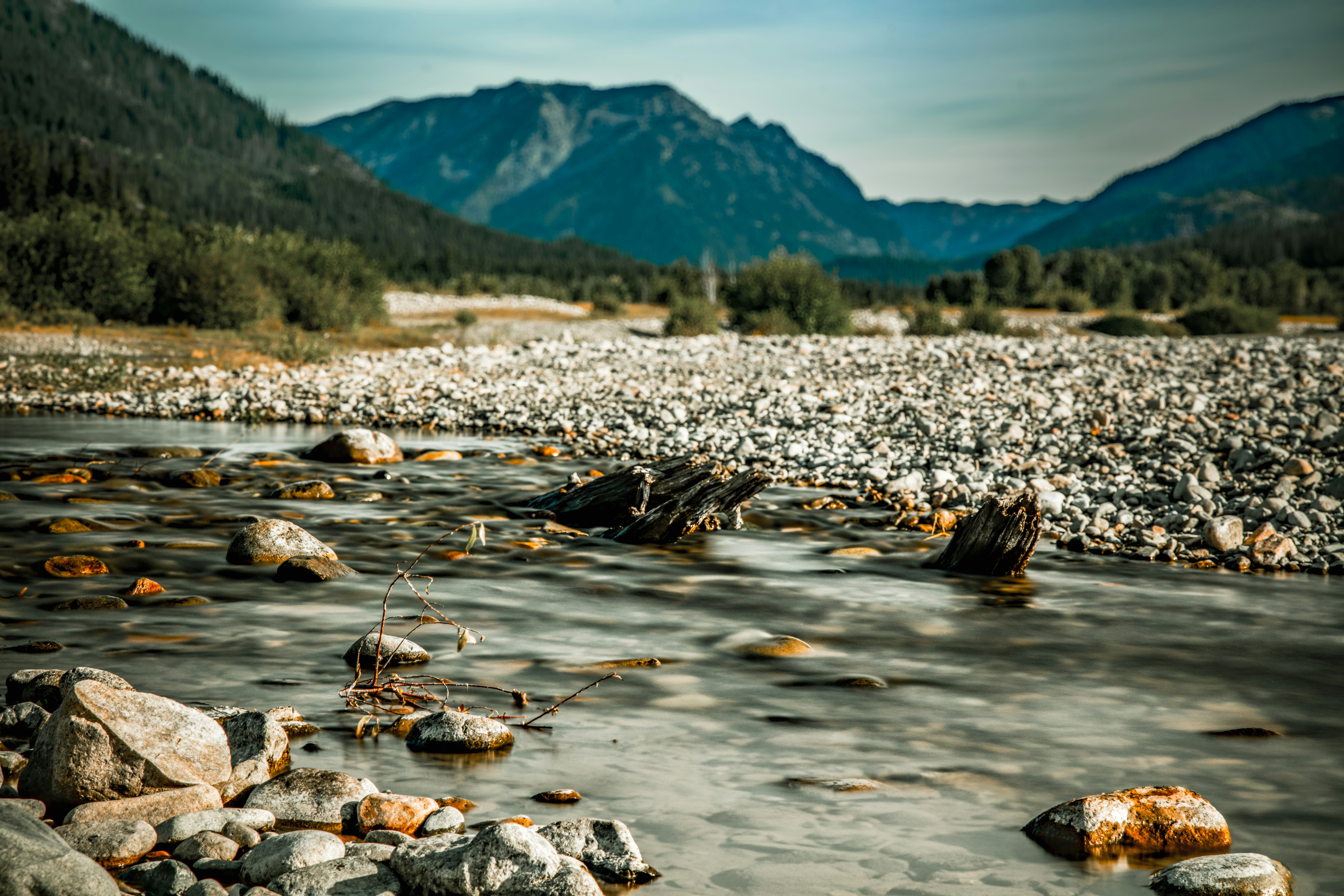 A river with rocks in it and mountains in the background