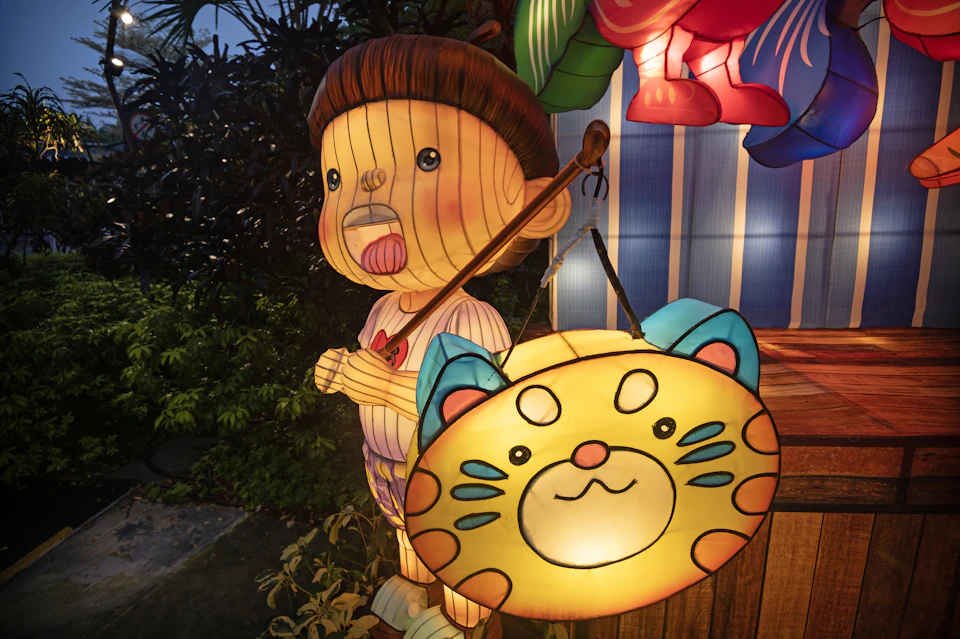A glowing Mid-Autumn Festival lantern of a child carrying a cat-faced lantern, part of the display at Gardens by the Bay in Singapore