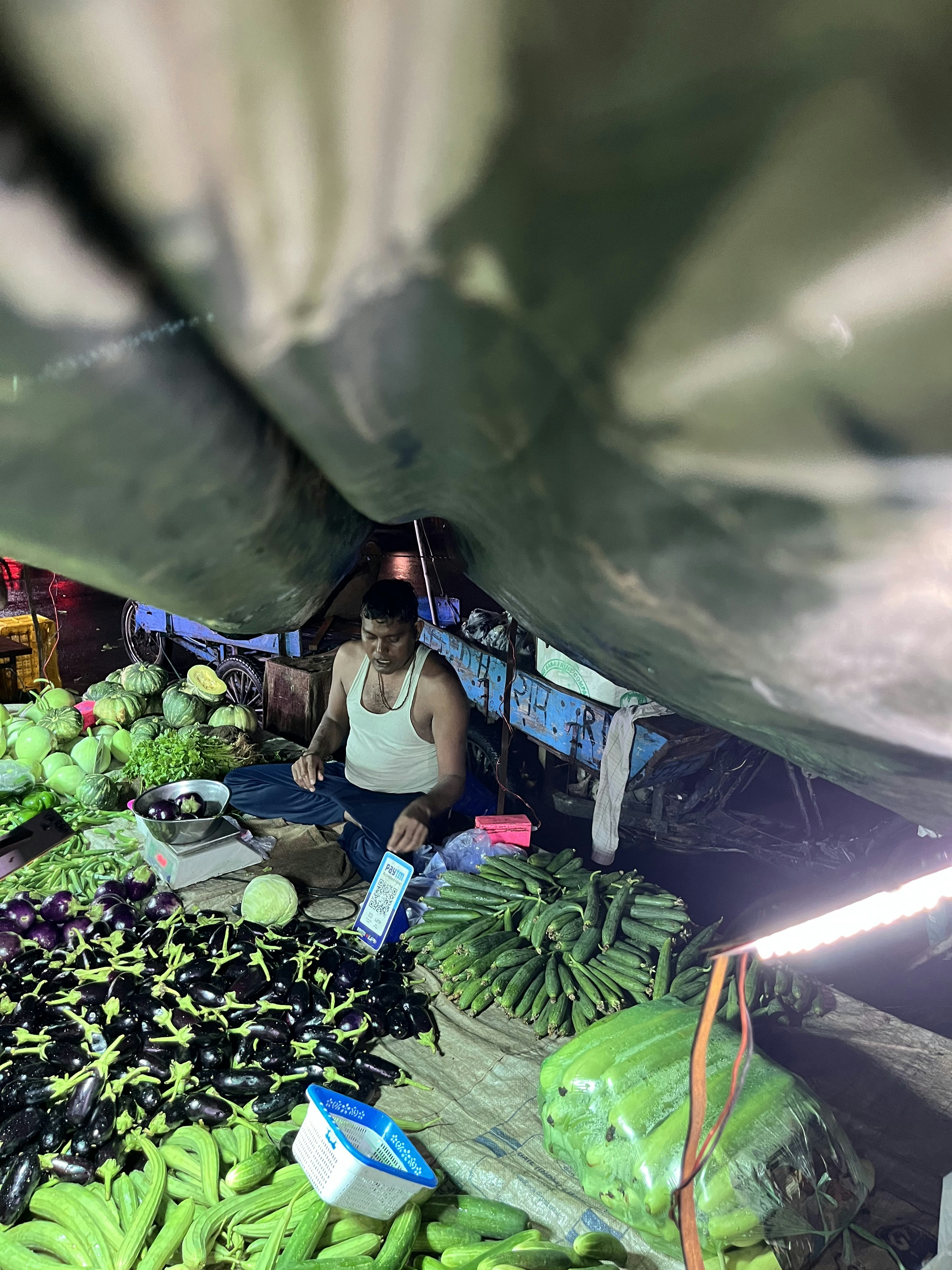 A man sitting in a room filled with lots of produce