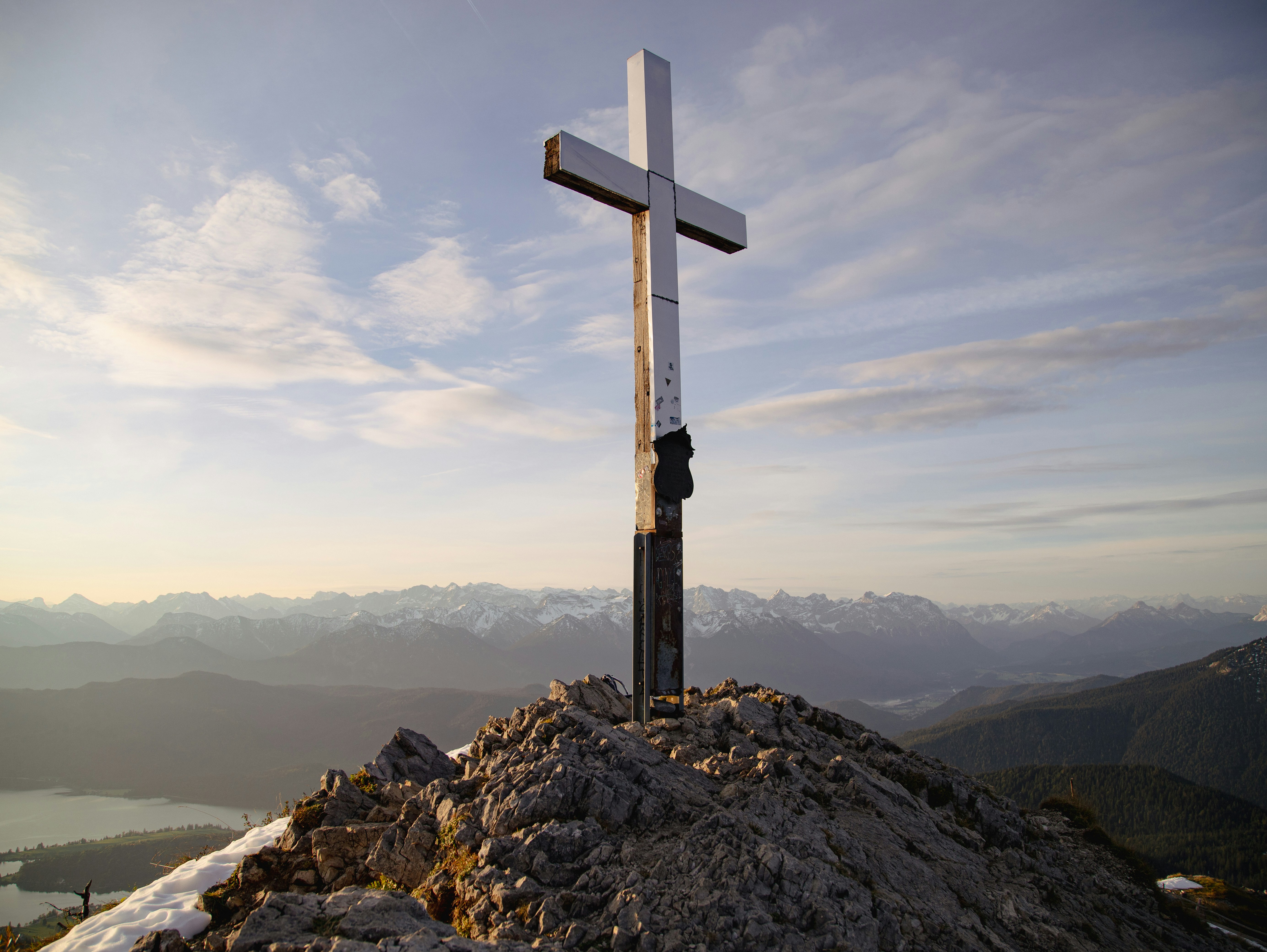 A cross on top of a mountain with a sky background