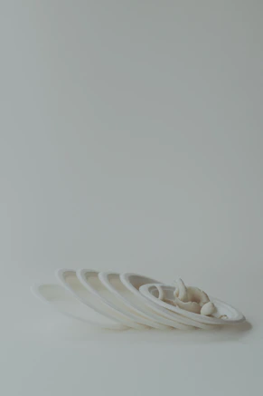 A stack of white plates sitting on top of a white table