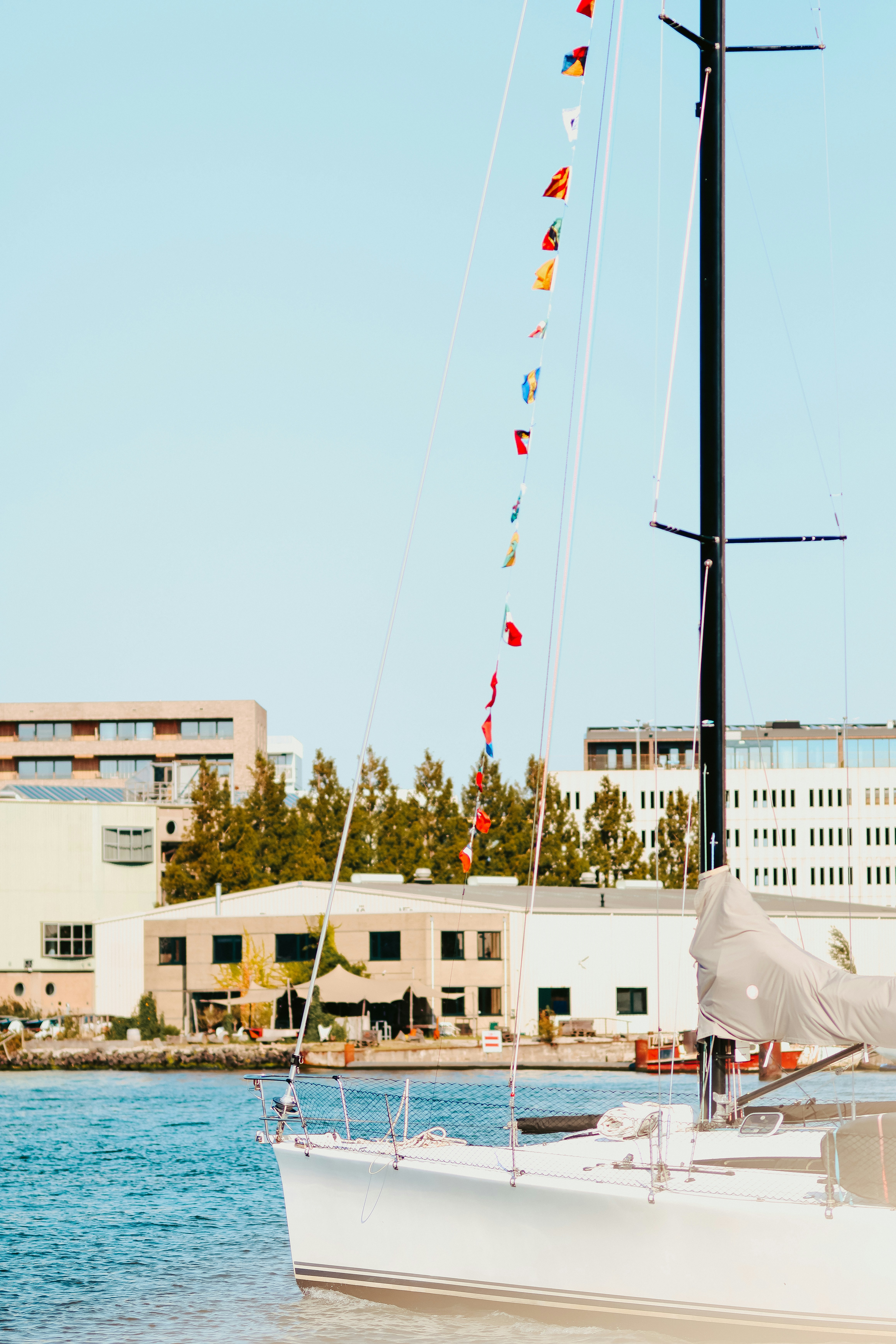 A sailboat in the water with buildings in the background