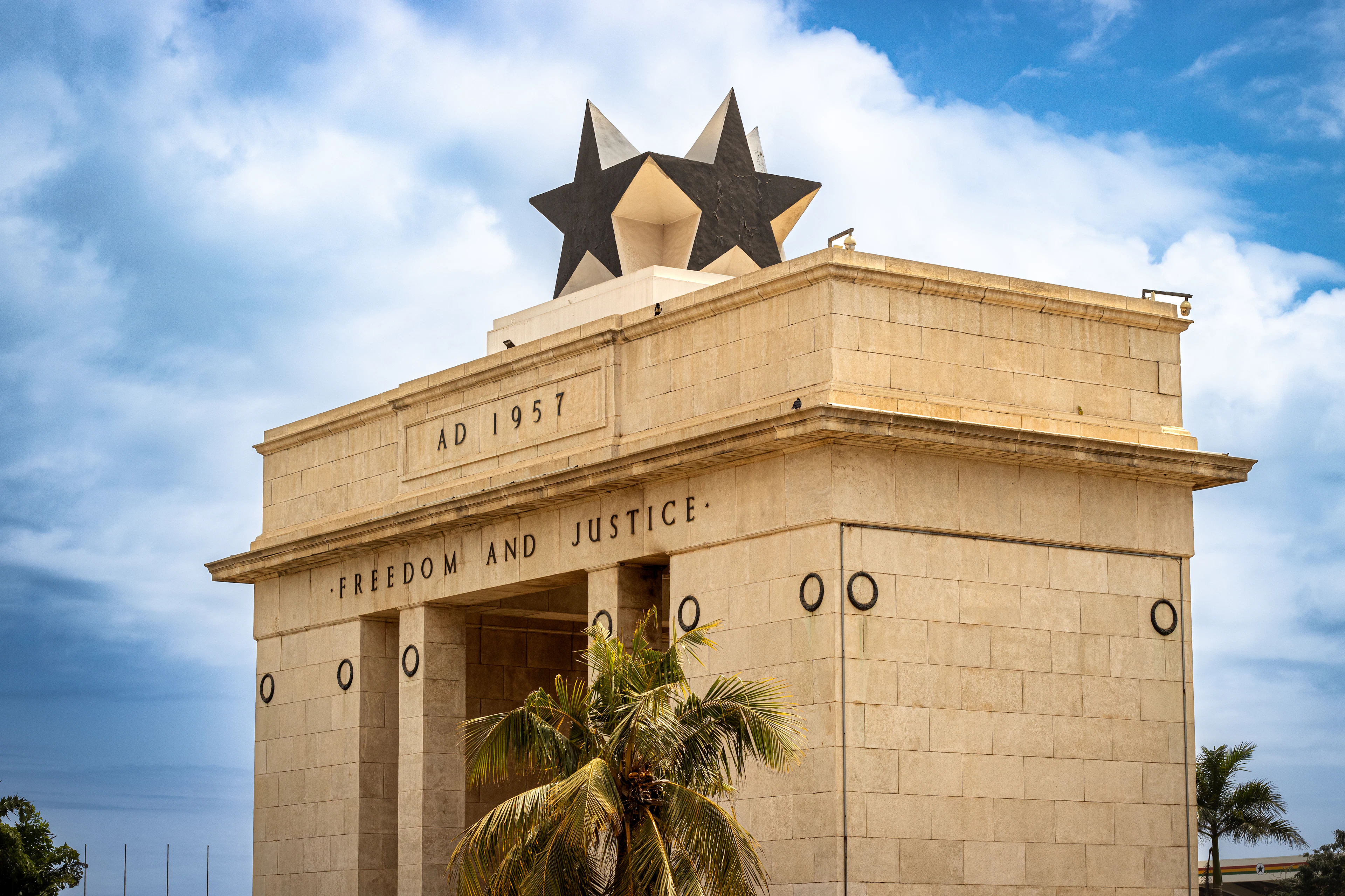 Accra's Independence Arch, inscribed AD 1957 Freedom and Justice, against a bright sky