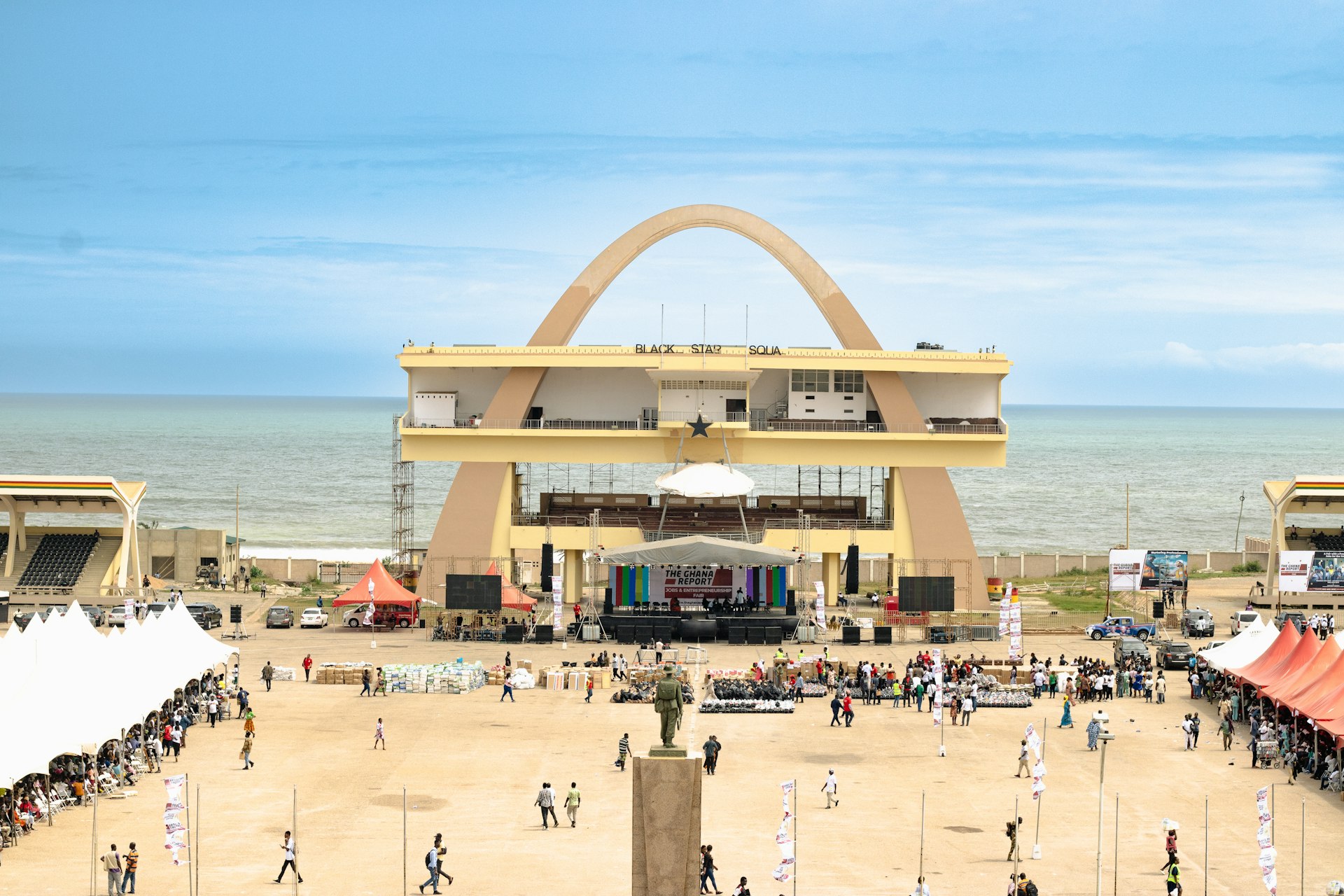 Sunny aerial view of a lively beach in Accra with tents and visitors enjoying the climate