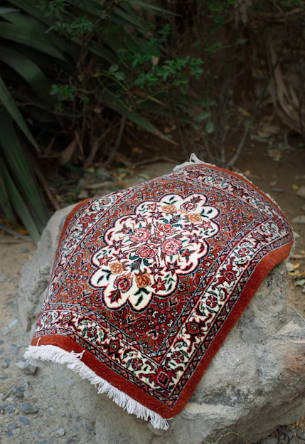 A red and white oriental rug sitting on top of a rock