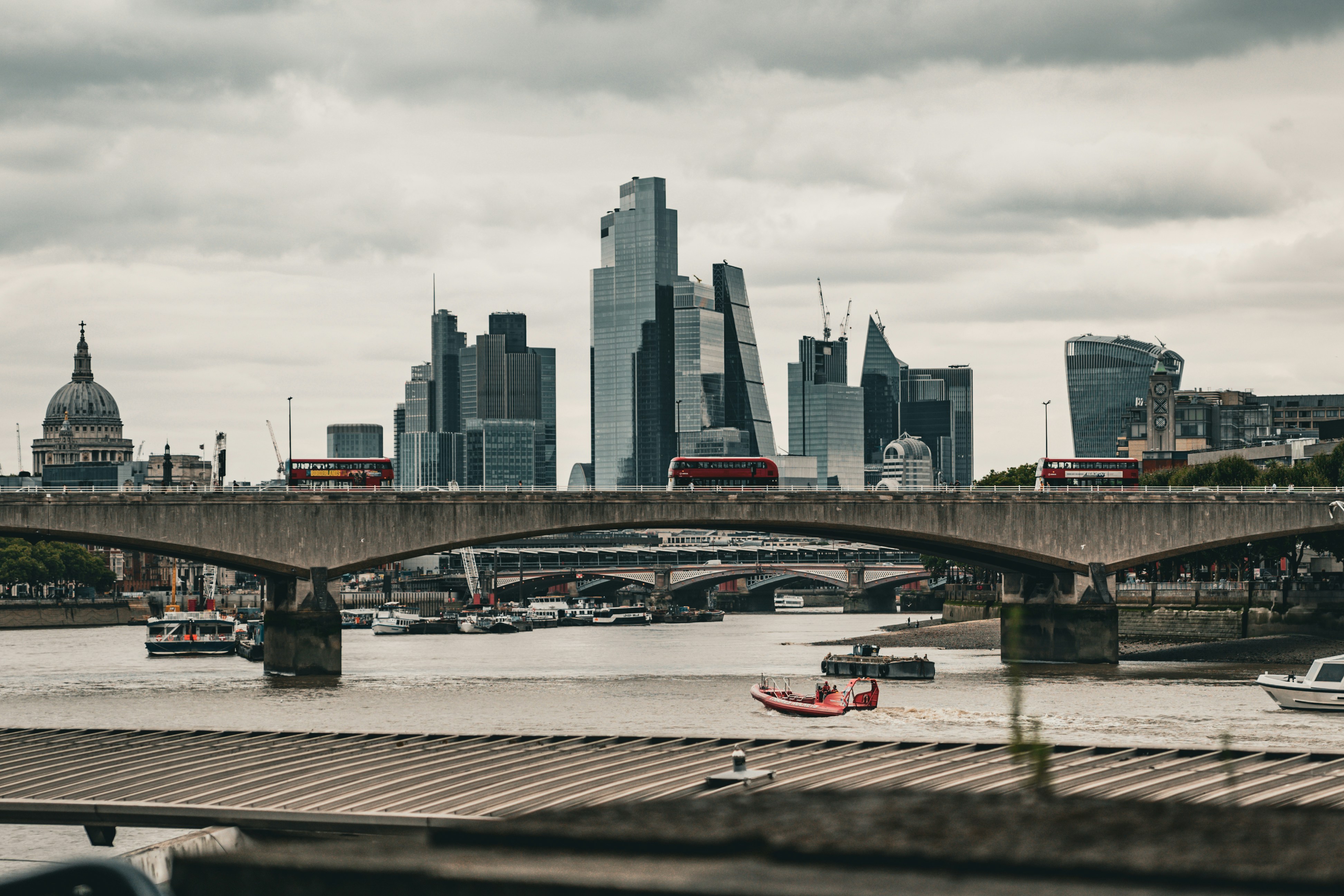 A view of a river with a bridge and a city in the background