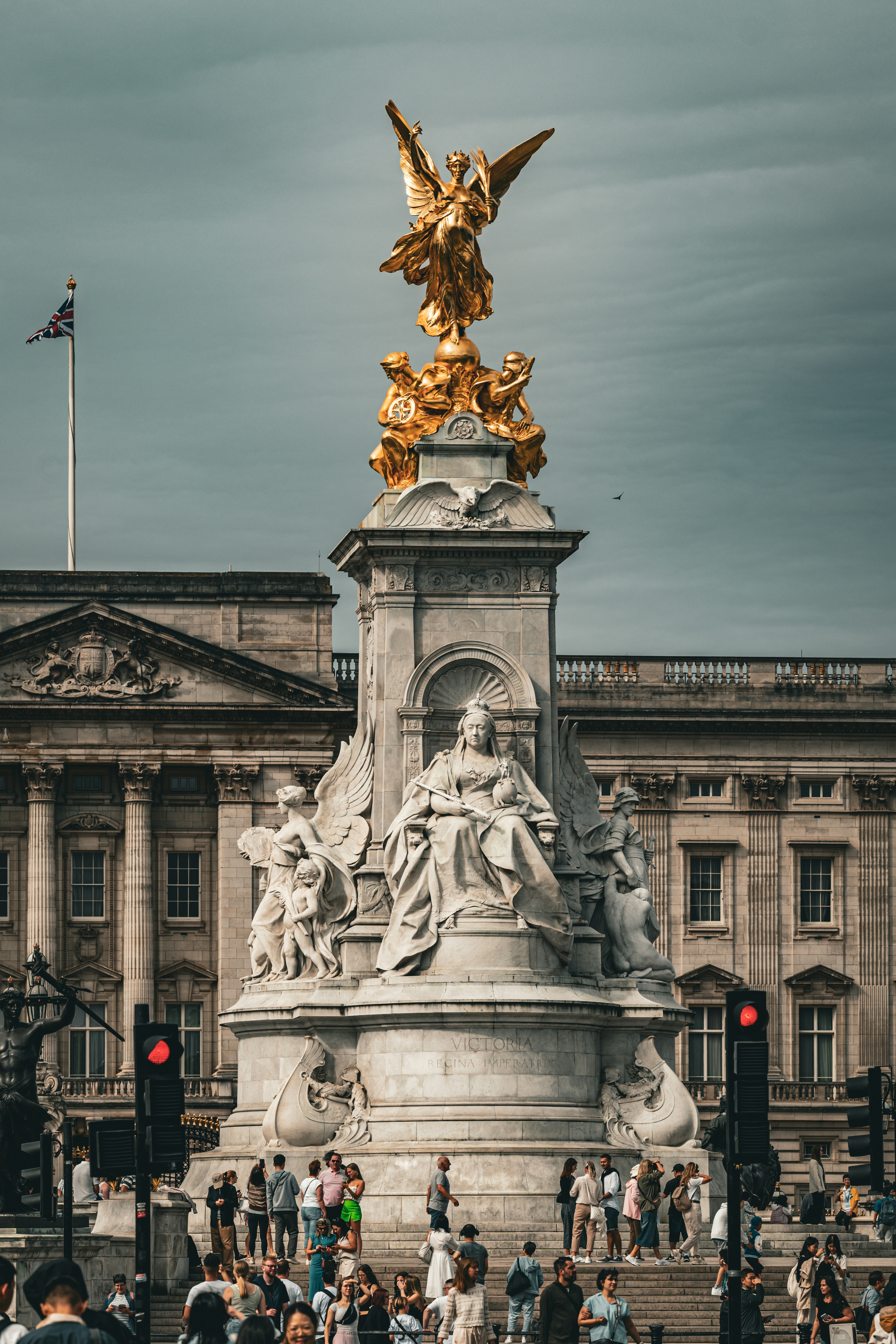 A crowd of people standing around a statue in front of a building