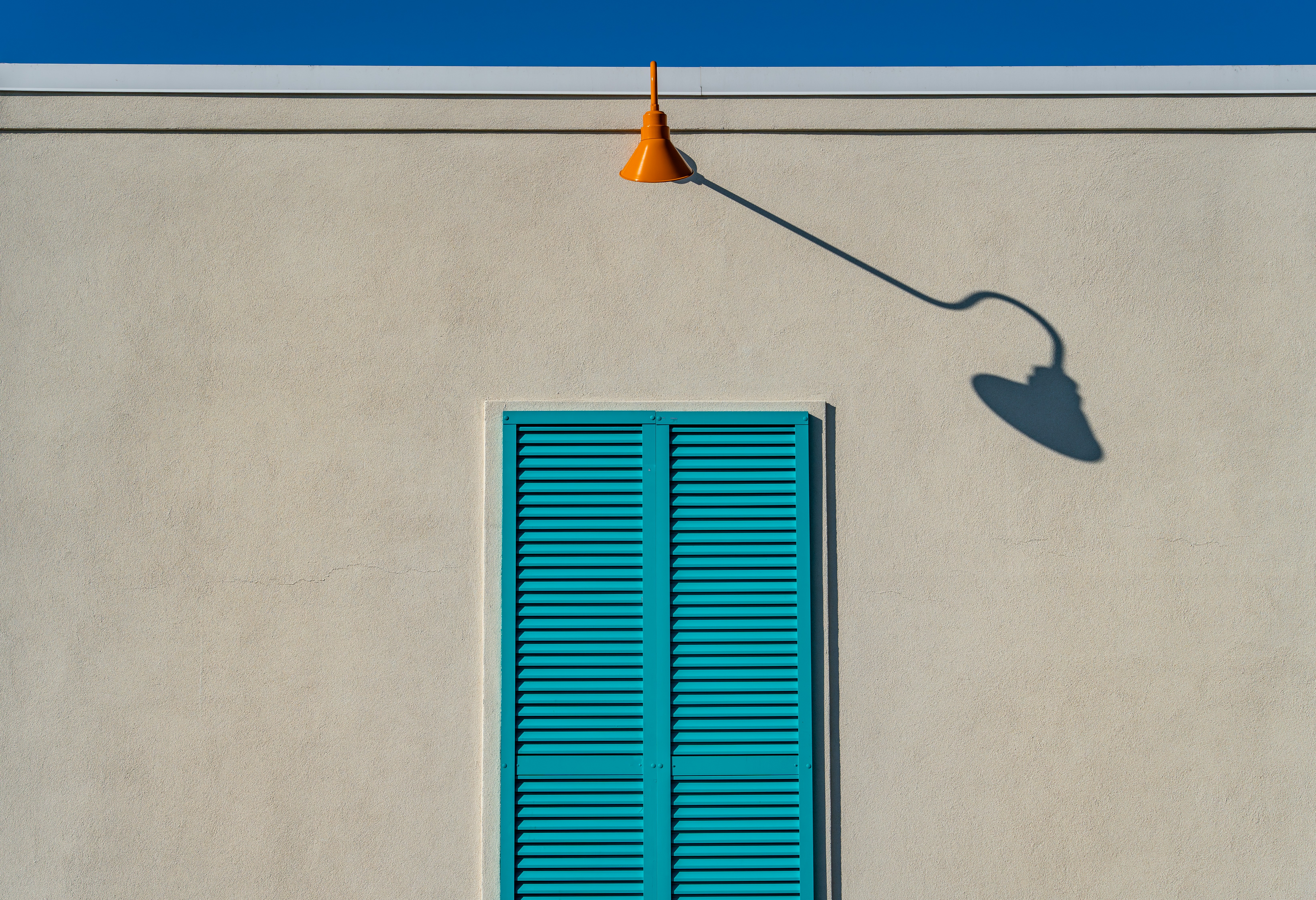 A blue window and a white building with a blue door