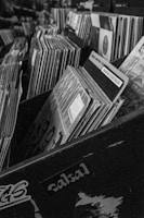 A black and white photo of a box full of records