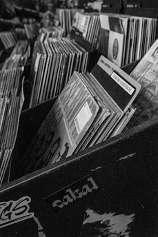 A black and white photo of a box full of records