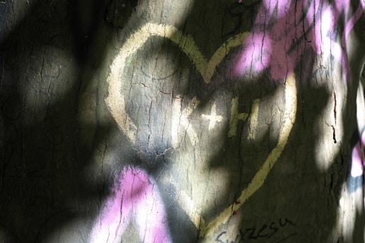 A wall that has graffiti on it with a heart drawn on it