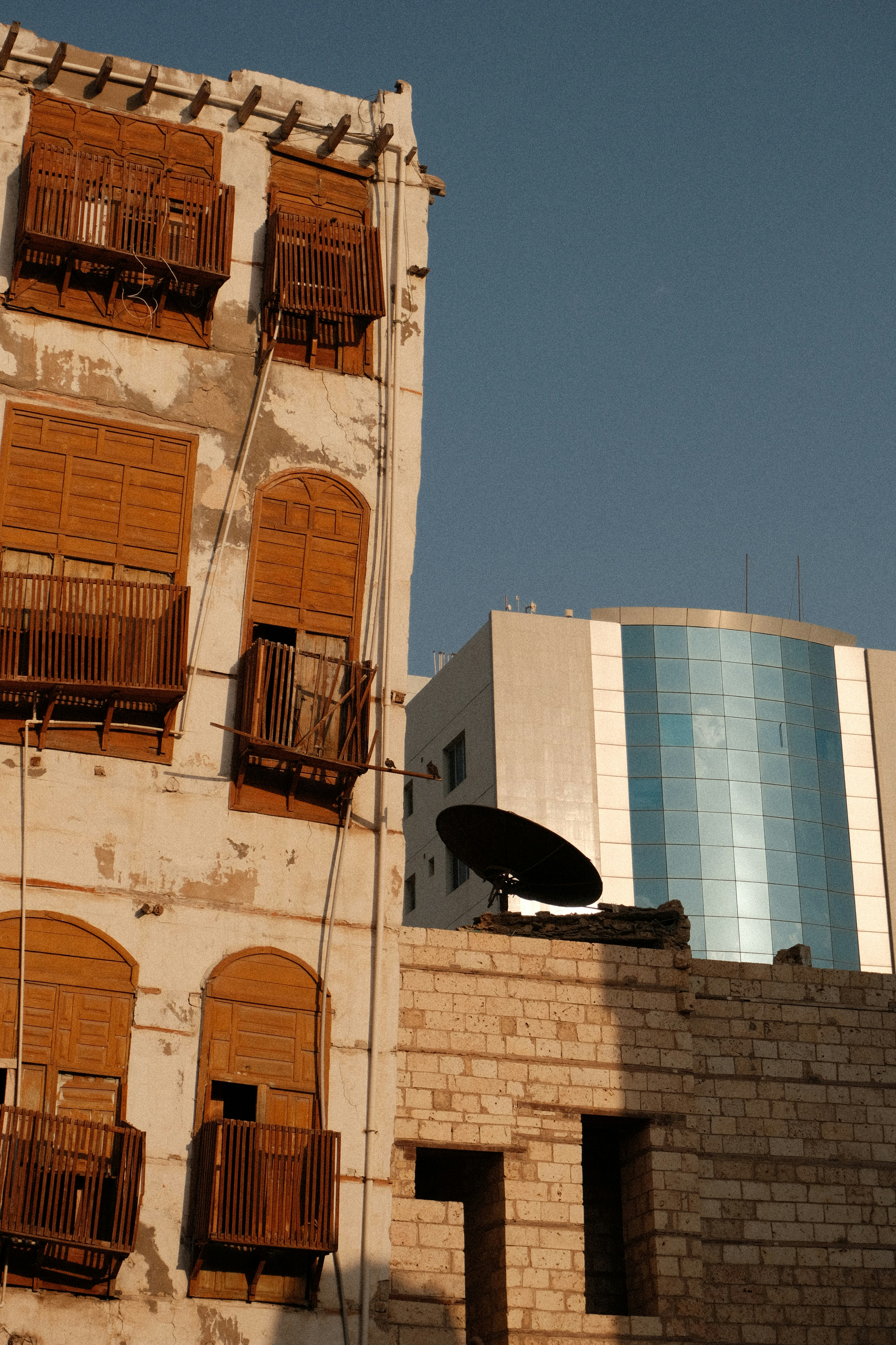A tall building with wooden balconies next to a brick wall