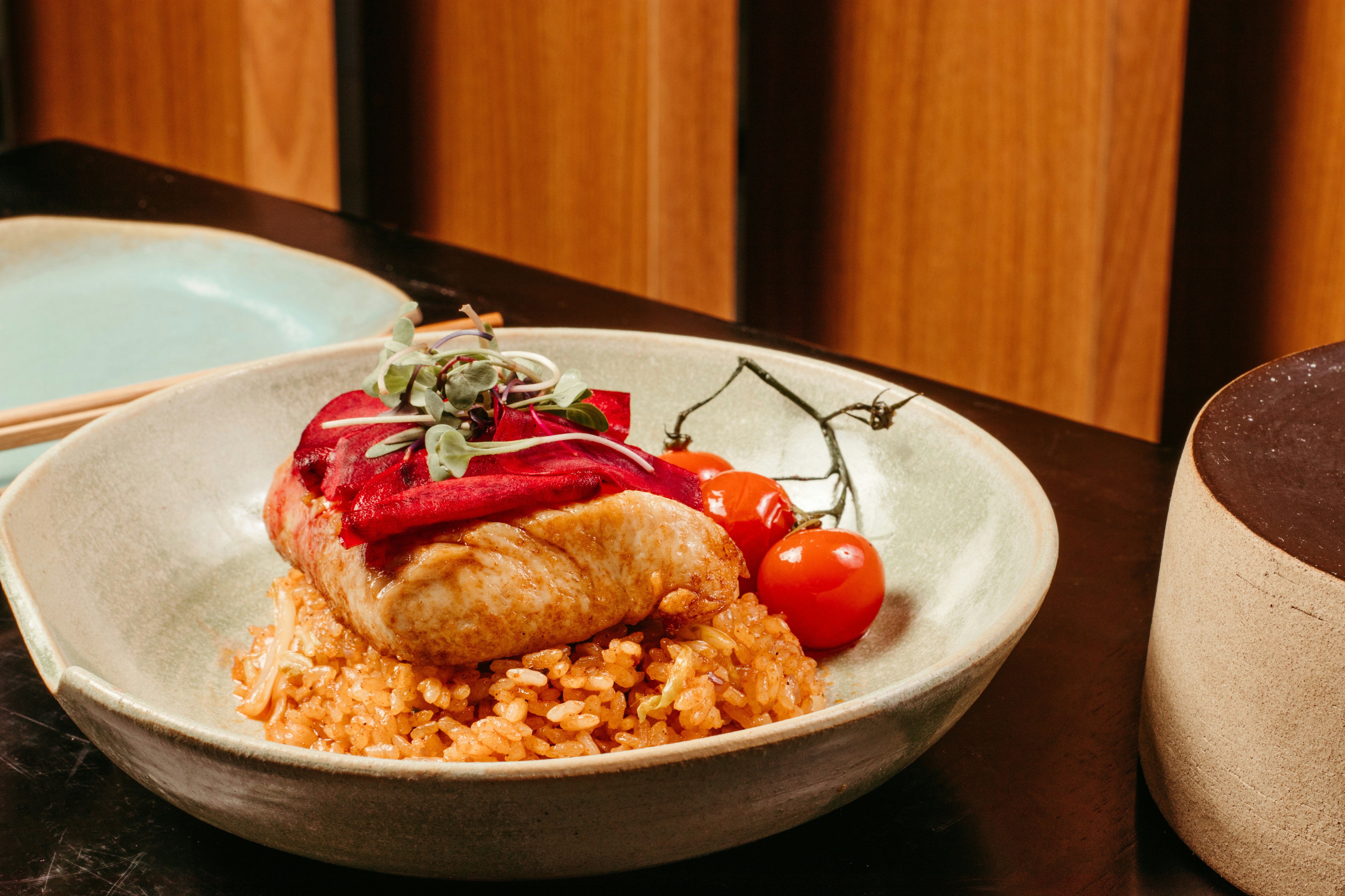 Enchilada with cherry tomatoes on rice in a white bowl