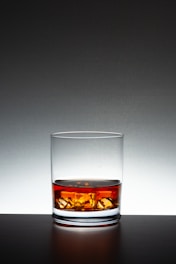 A glass of whiskey sitting on top of a table