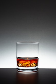 A glass of whiskey sitting on top of a table