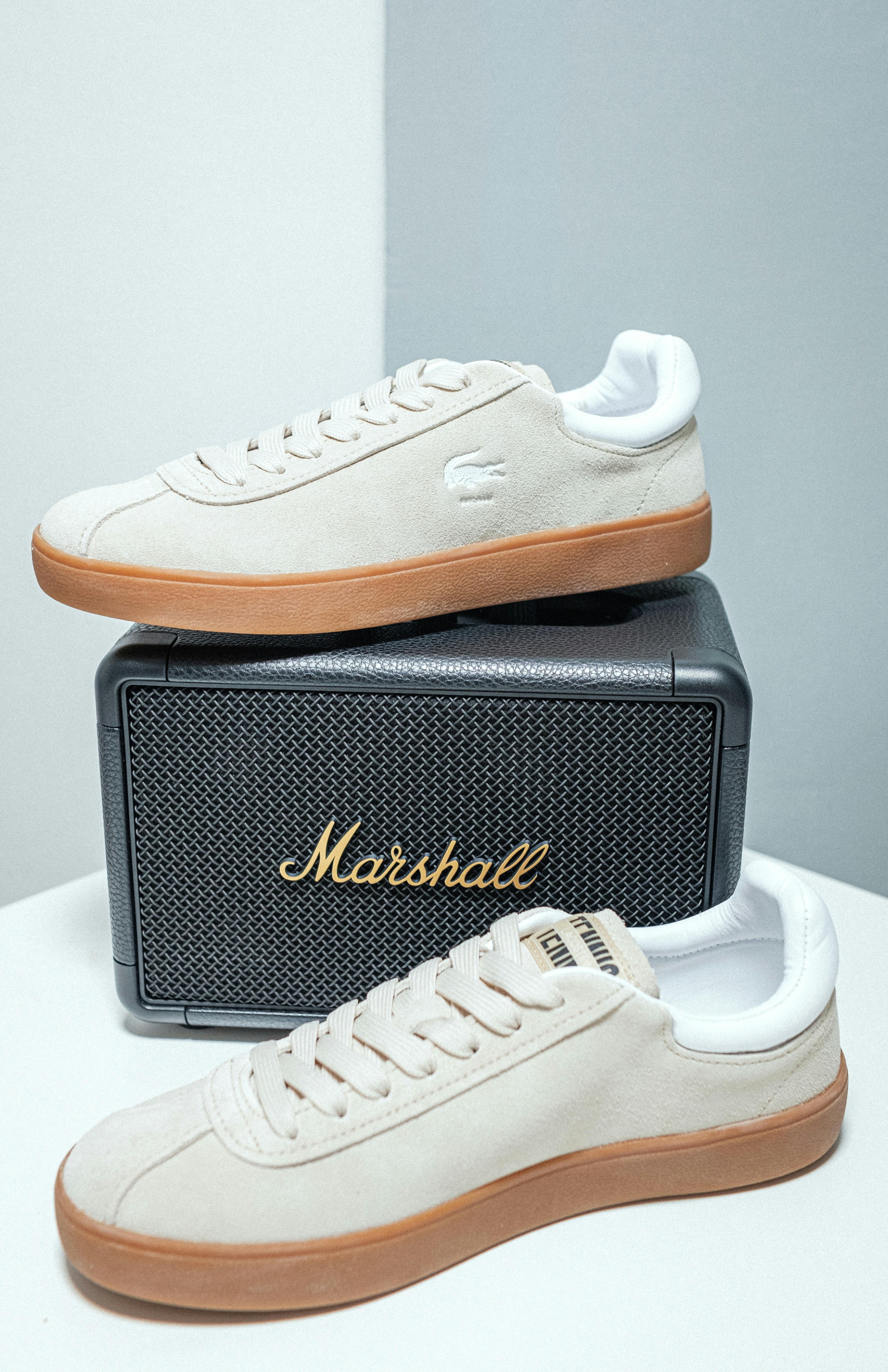 A pair of white sneakers sitting on top of a box