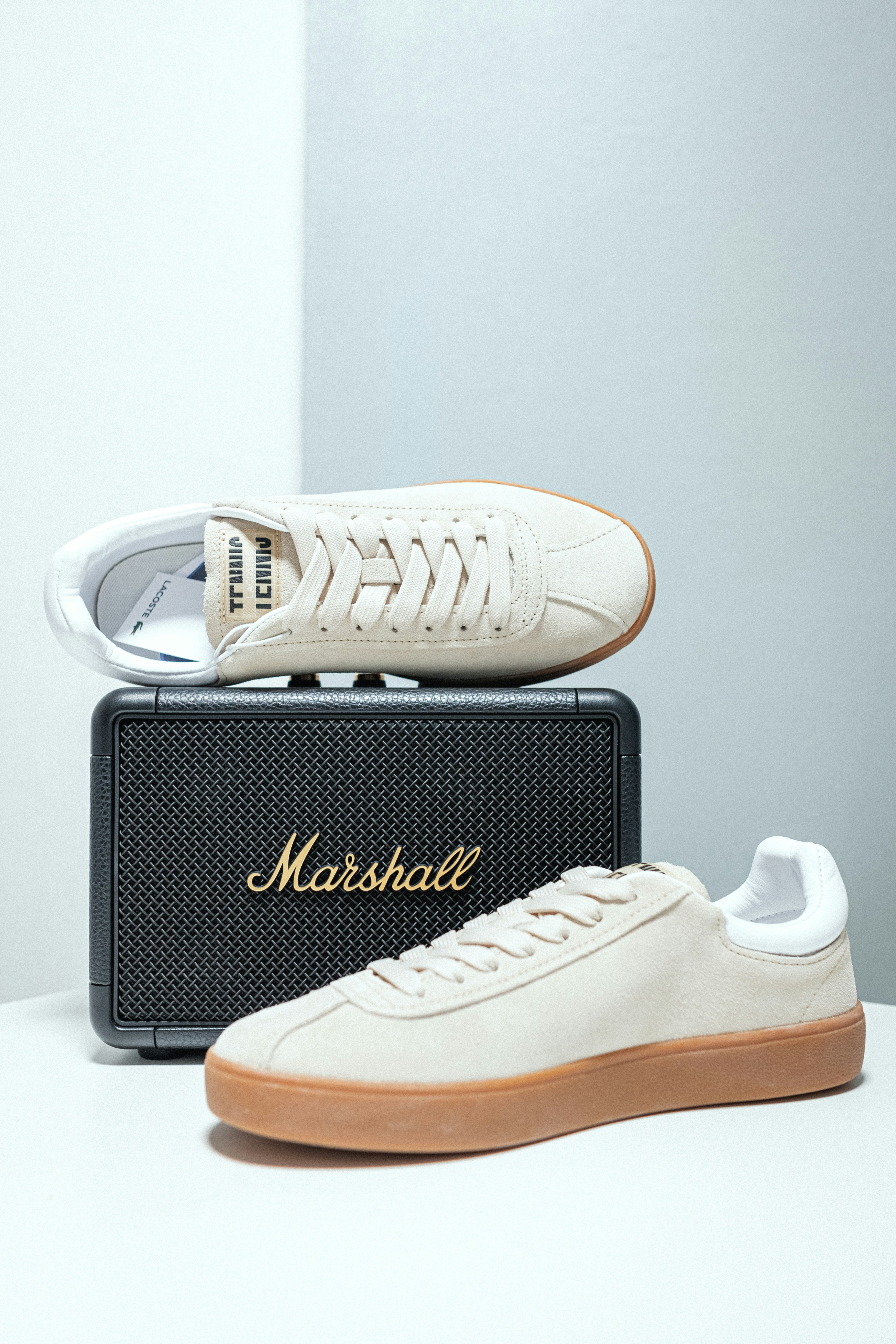 A pair of white sneakers sitting on top of a white box