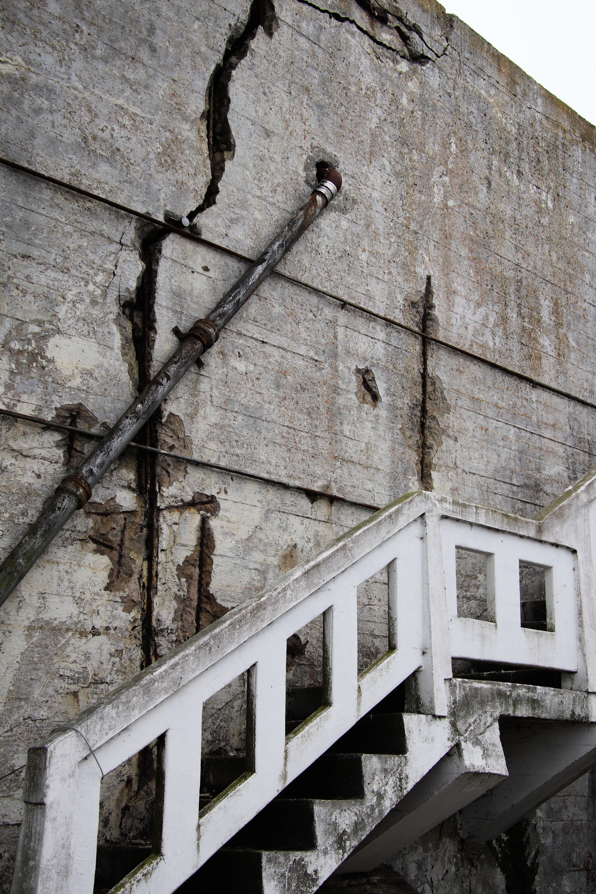 A white stair case next to a brick wall