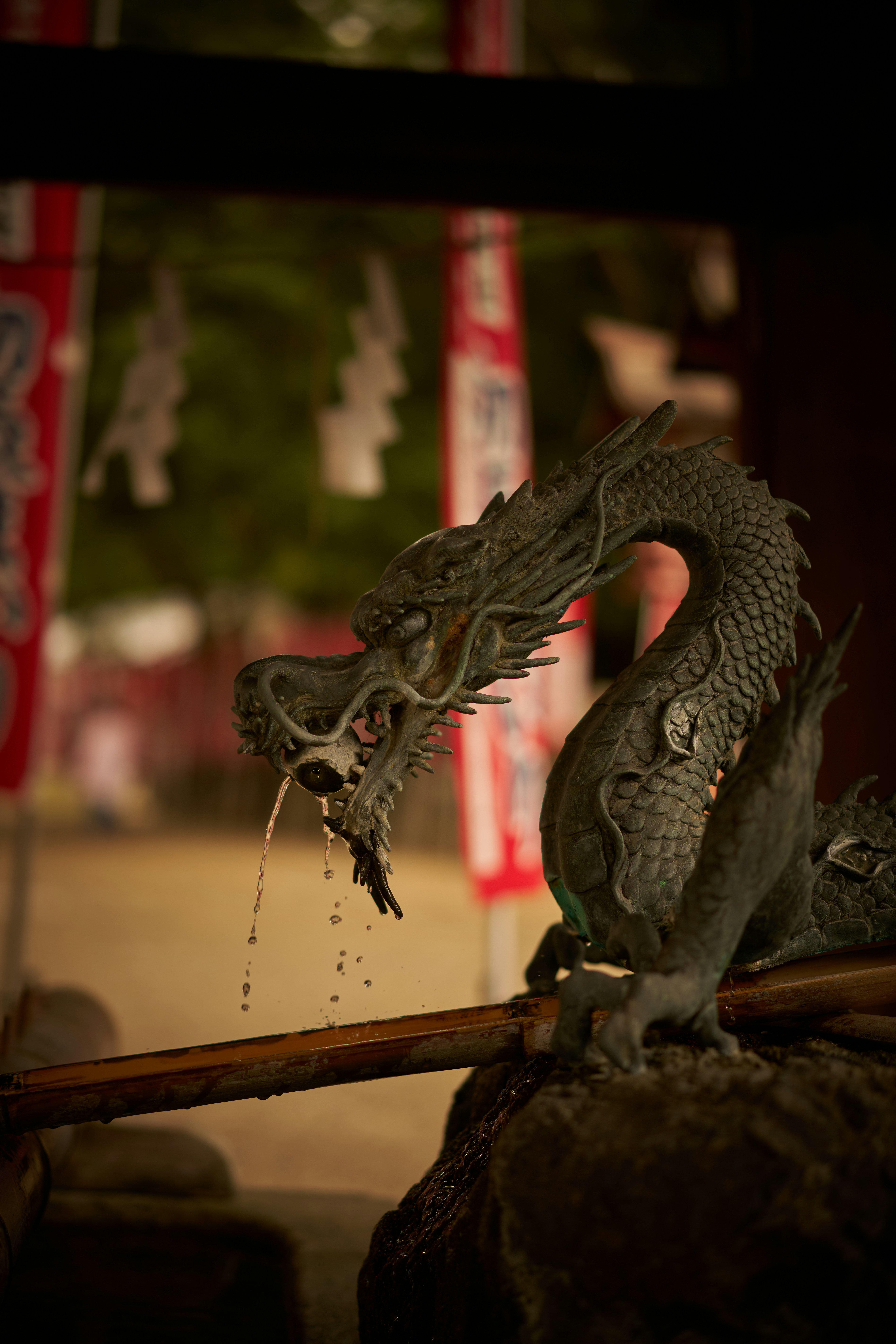 A statue of a dragon drinking water from a pipe