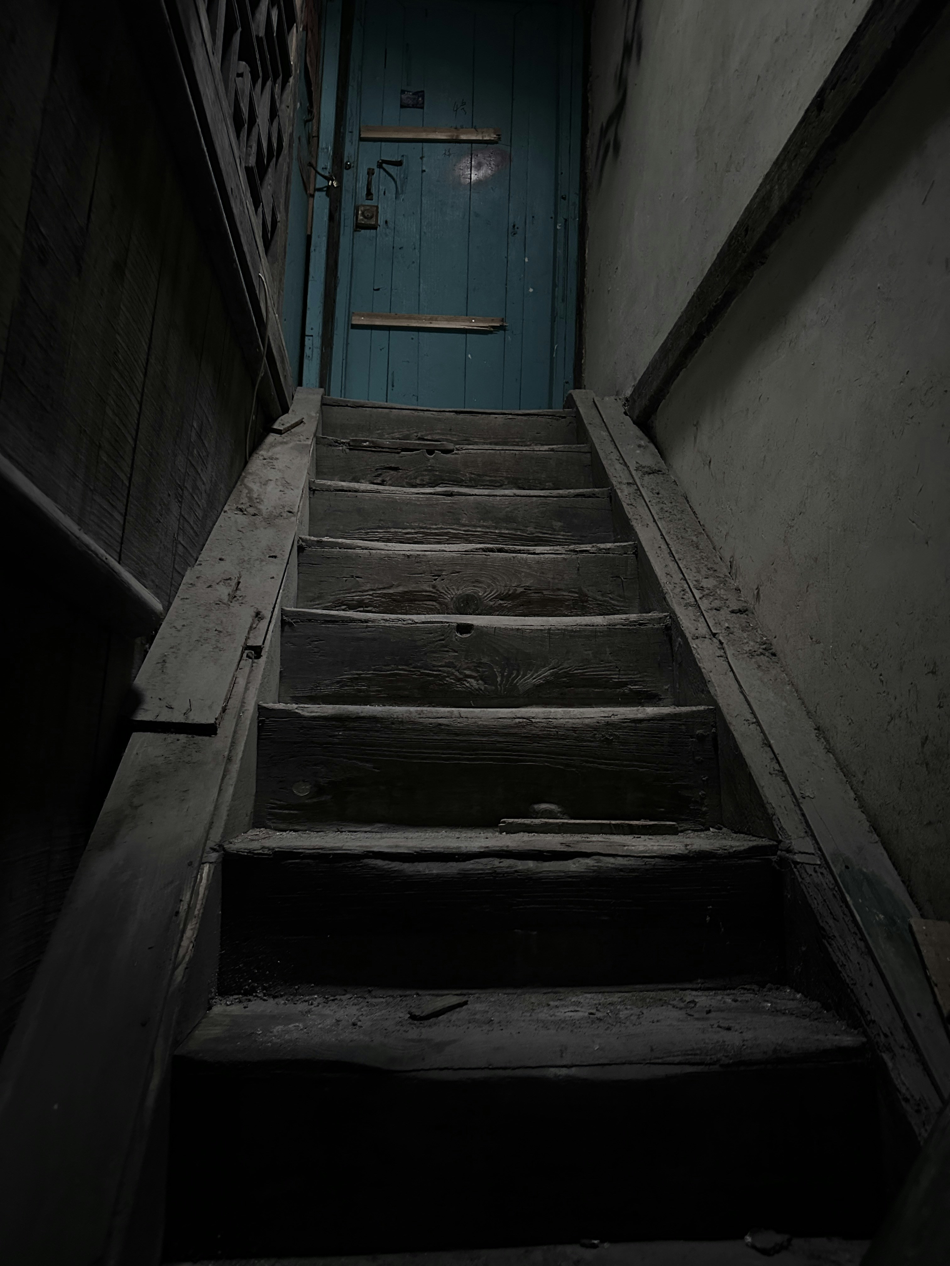 A set of stairs leading up to a blue door