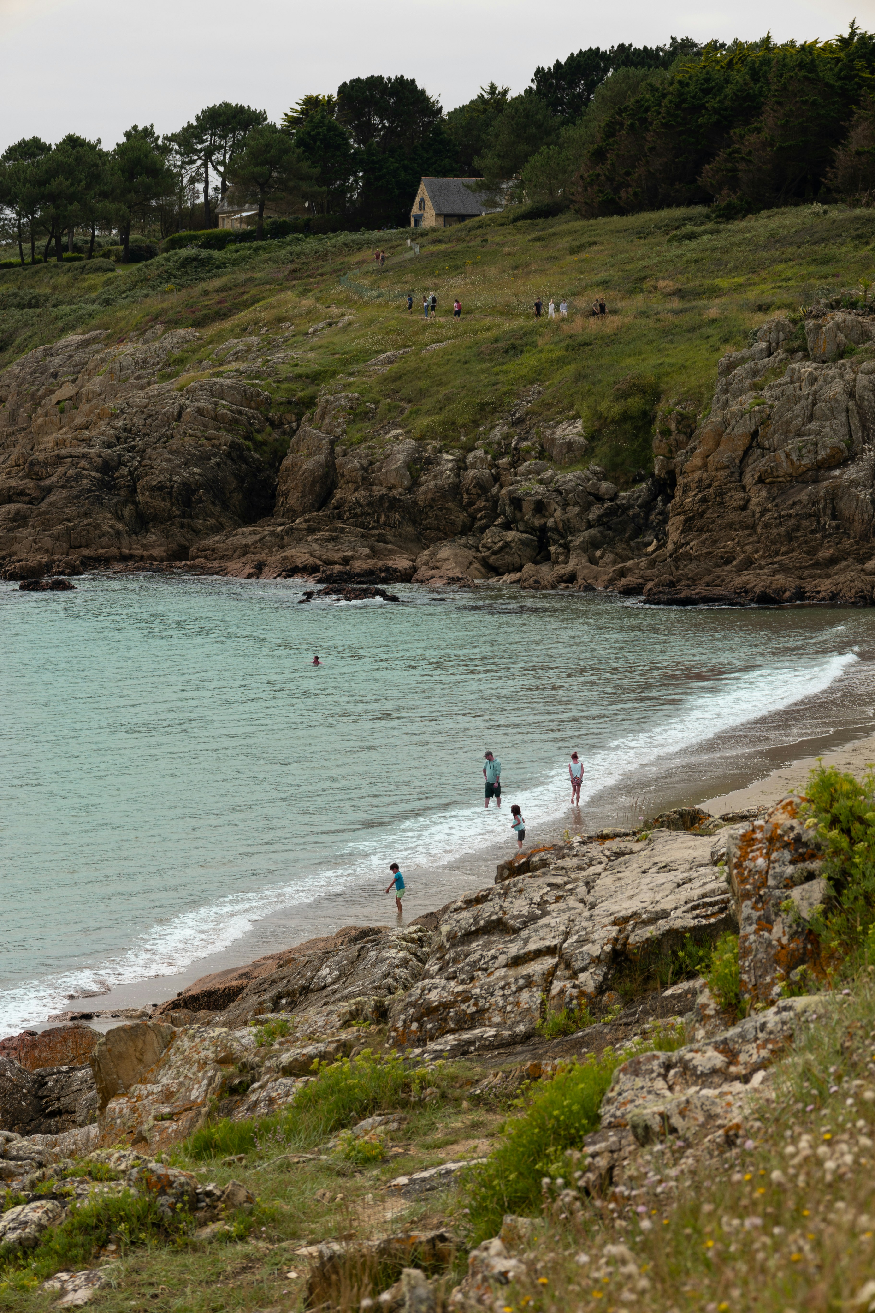 A group of people standing on top of a sandy beach